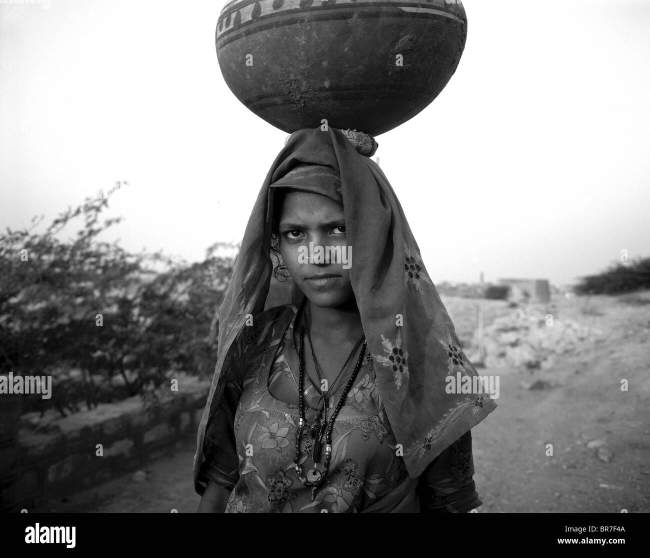 Ragazza Rajistani portando acqua (bianco e nero) Foto Stock
