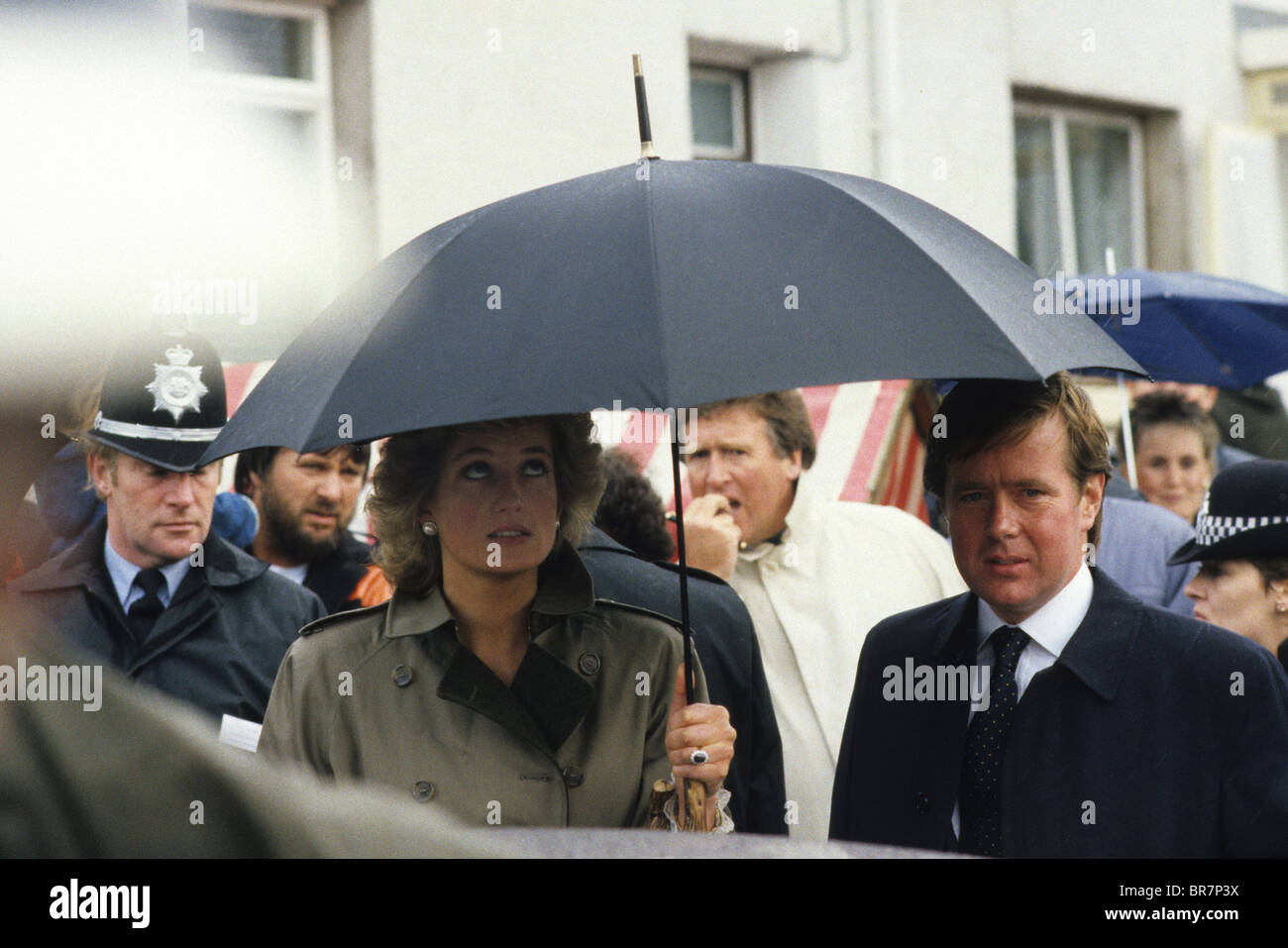 Principessa Diana sotto l'ombrello con la guardia del corpo della polizia Ken Wharfe con James Whitaker corrispondente reale del Daily Mirror dietro il 1987. Foto di DAVID BAGNALL Foto Stock