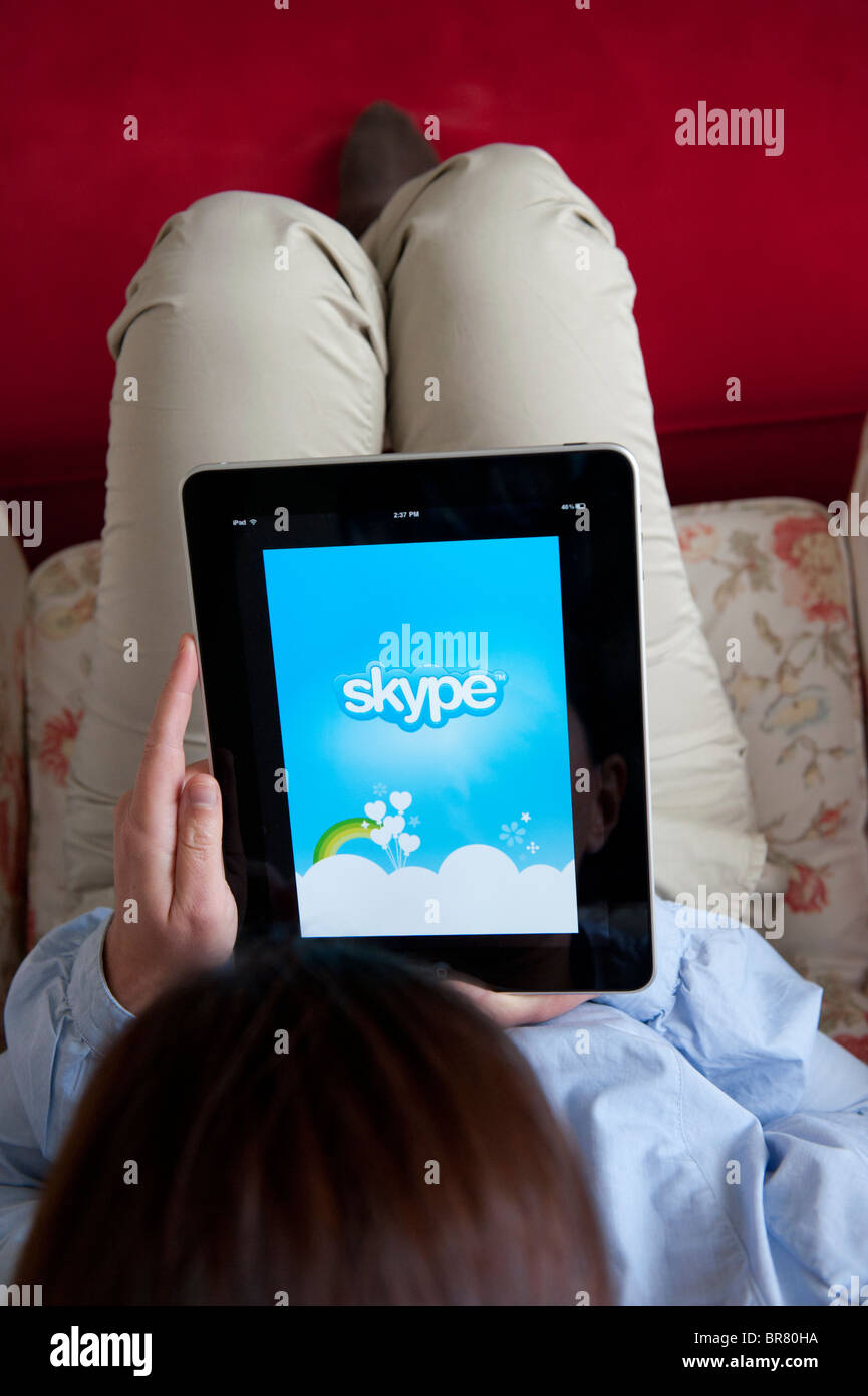 Donna che utilizza computer tablet iPad per effettuare chiamate tramite Skype servizio telefonico Internet Foto Stock