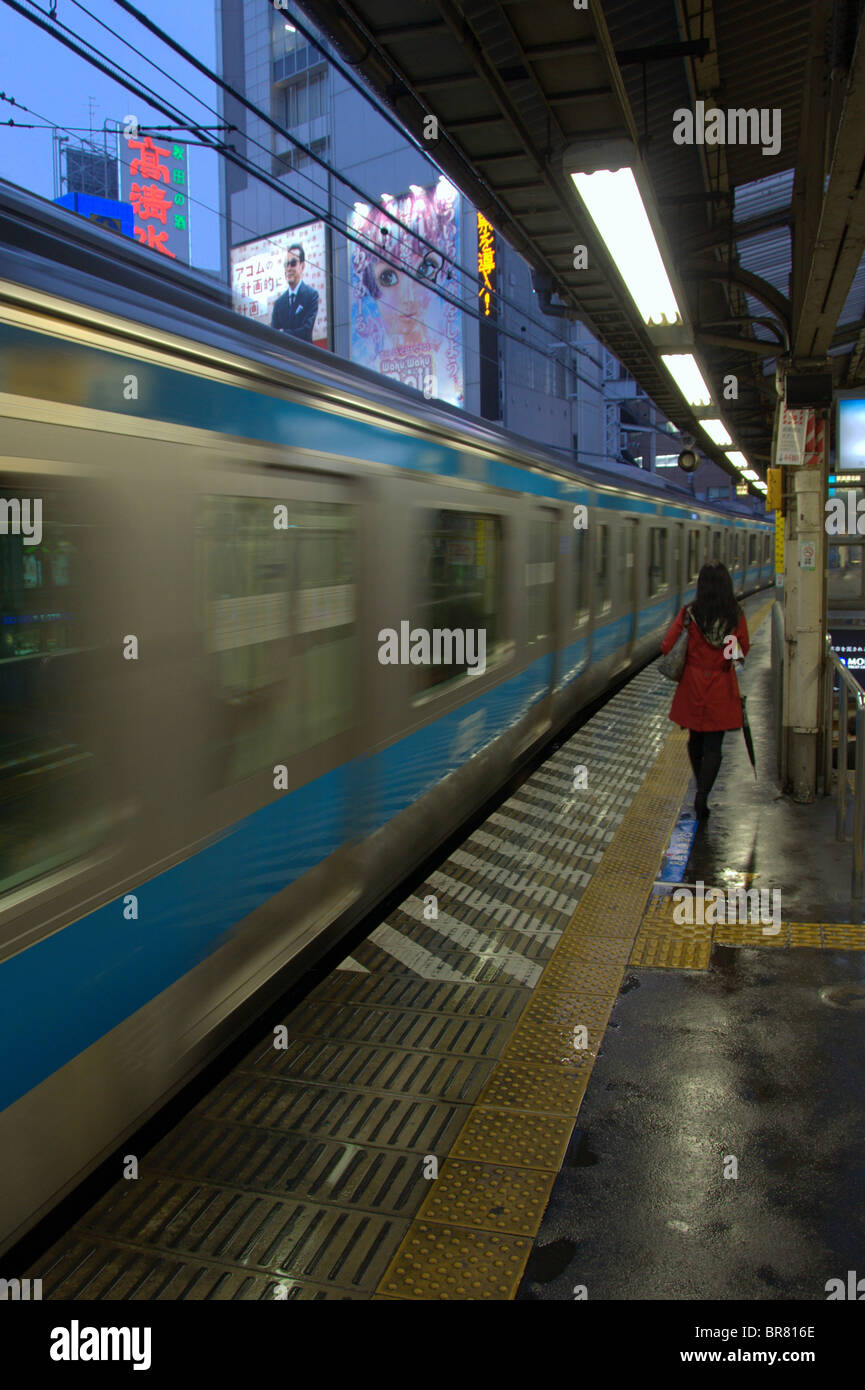 Donna che cammina per la cattura di un Yamanote treno alla Stazione di Shimbashi, Tokyo, Giappone Foto Stock