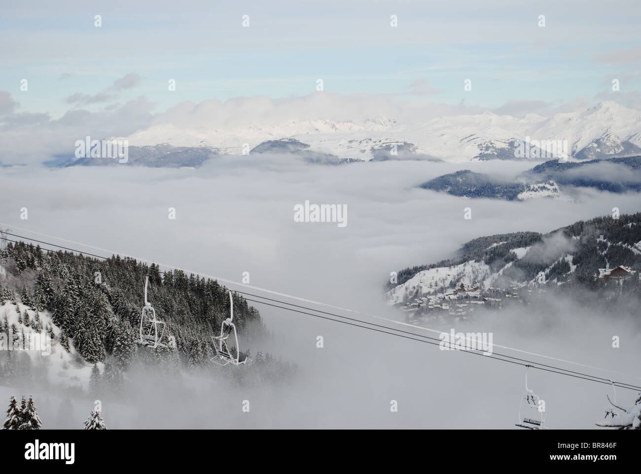 Vista del Trois Vallée ski resort coperti da cloud nelle Alpi francesi. Foto Stock