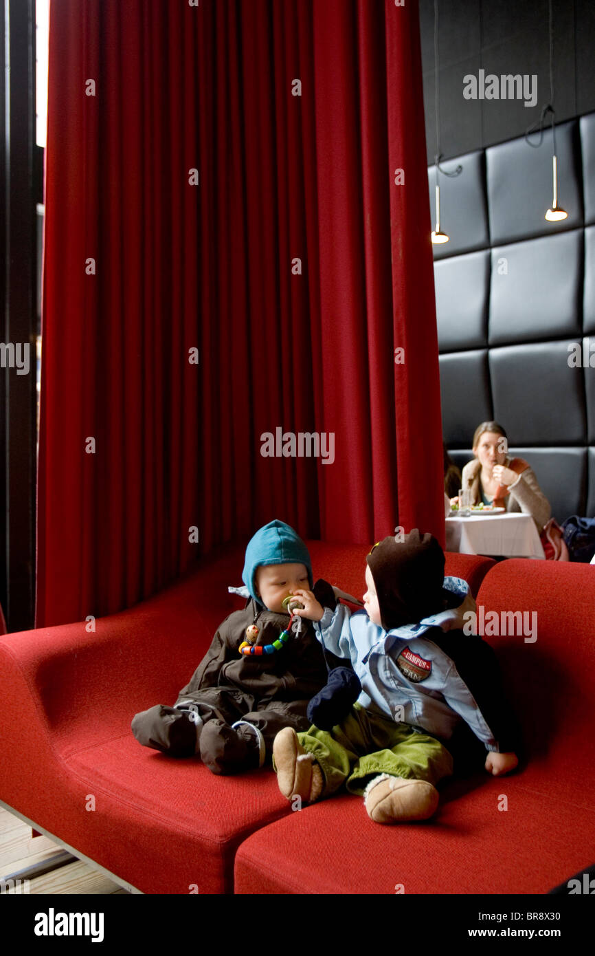 Due bambini di sedersi su un divano in un caffè di Arhus in Danimarca. Foto Stock