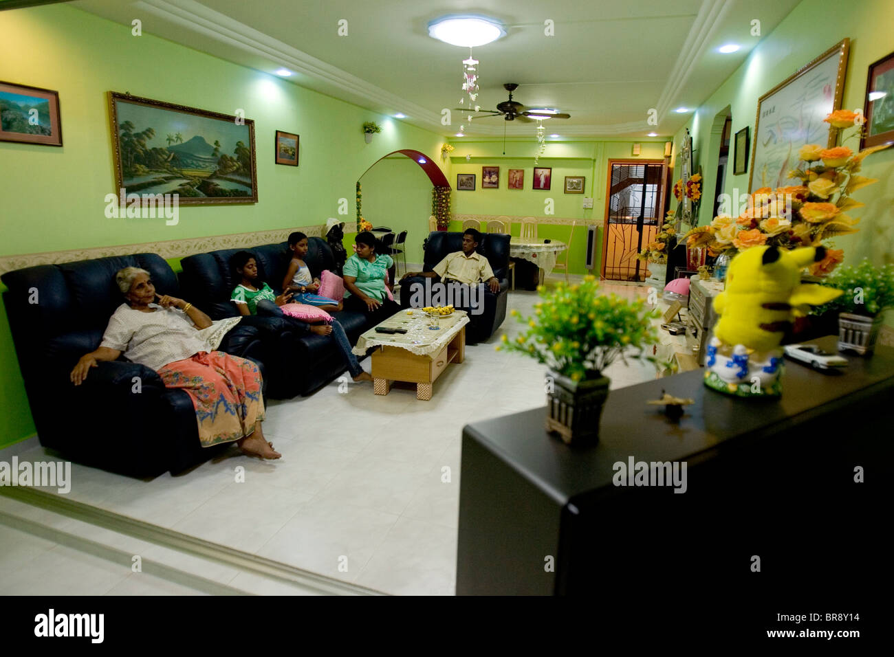 Una famiglia indiana guarda la televisione in un appartamento a Singapore. Foto Stock