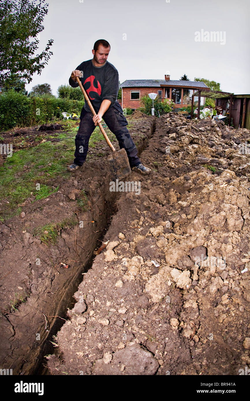 I tubi per il riscaldamento geotermico sistema essendo scavato nel giardino Foto Stock