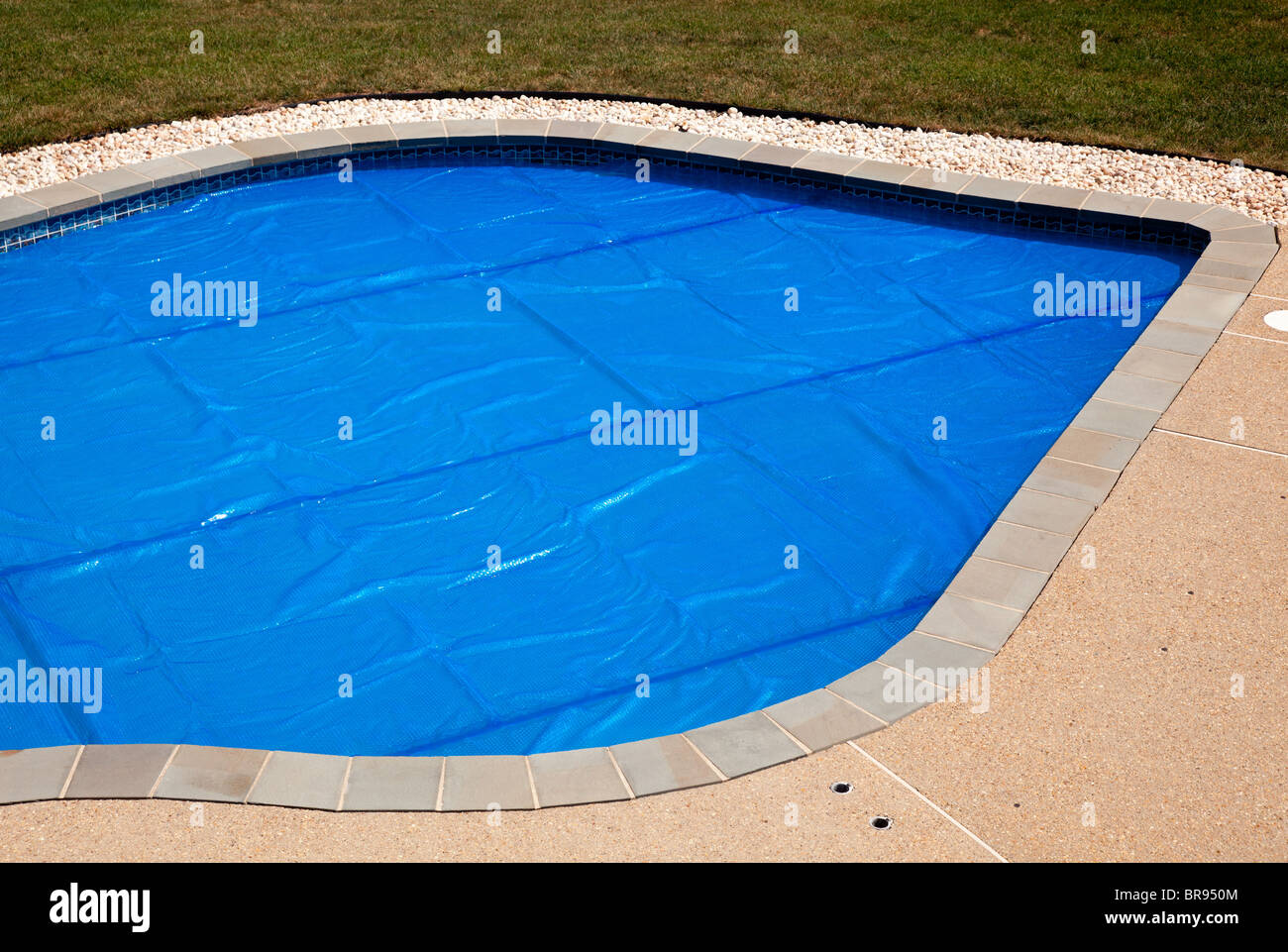 Piscina interna Piscina con solare blu Bubble wrap coperchio per mantenere il calore dell'acqua Foto Stock