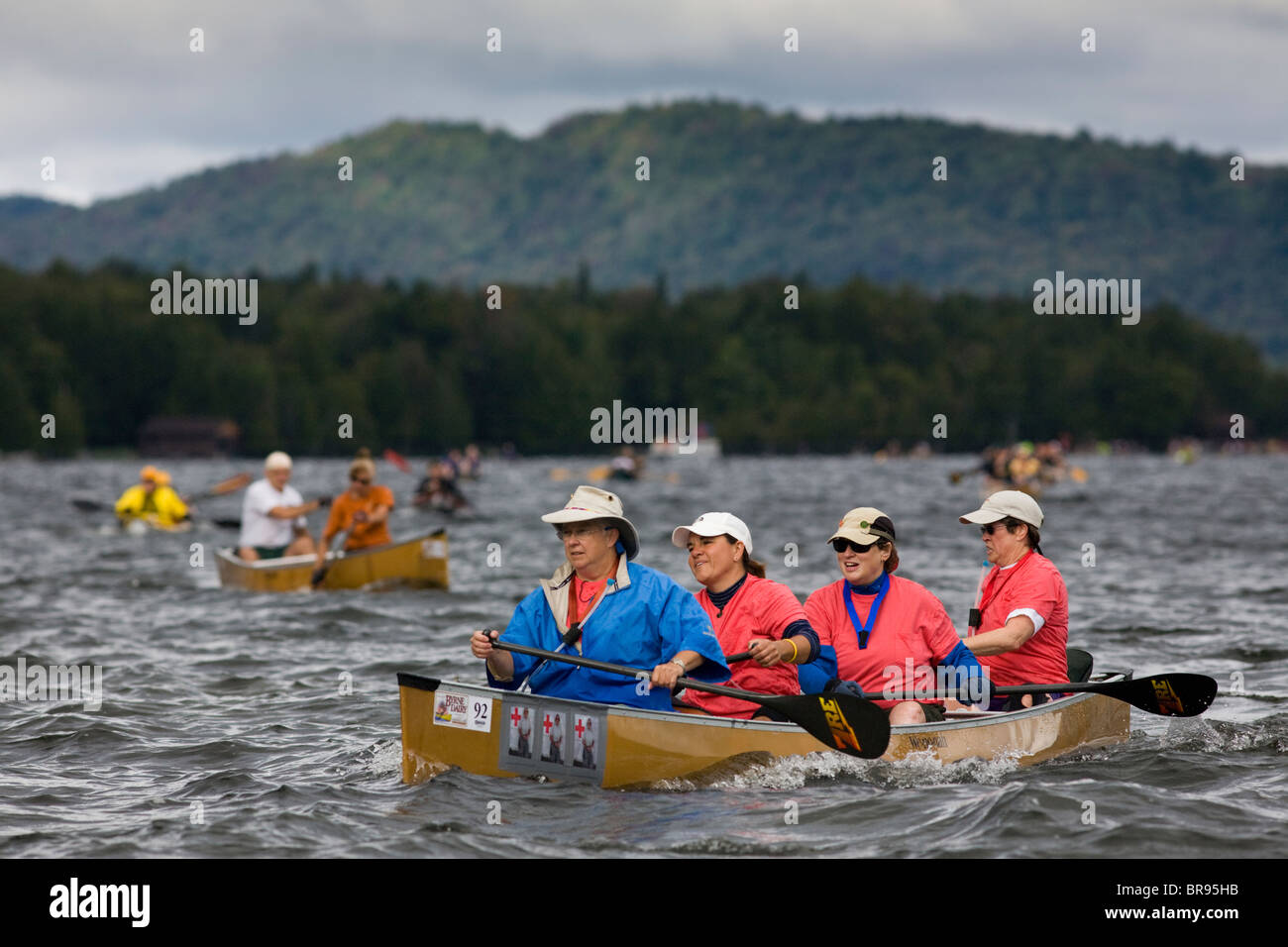 Quattro donne di mezza età dei rematori cross Fulton catena di laghi in ingresso, New York, durante Adirondack Canoe Classic, '90-Miler' Foto Stock