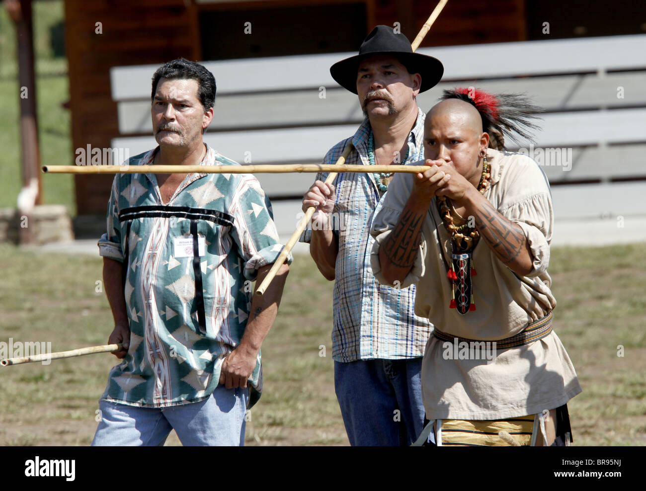 Un uomo Cherokee, membro dei guerrieri del gruppo AniKituhwa, soffia un dardo durante una cerbottana contest . Foto Stock