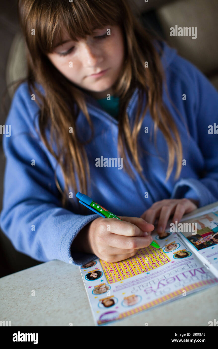 Ragazza adolescente facendo un puzzle libro mentre era in vacanza in una roulotte nel Regno Unito Foto Stock