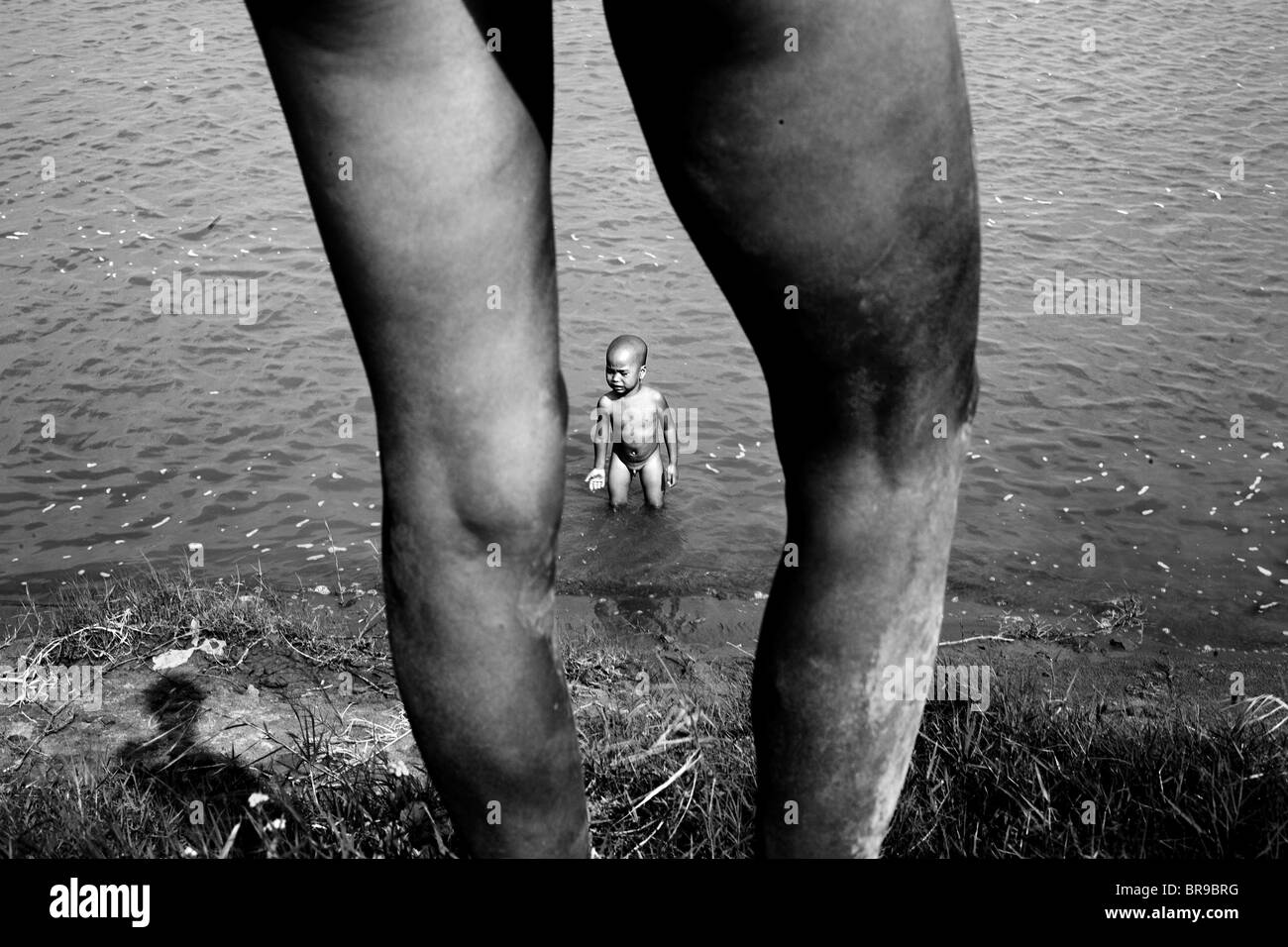 La Madre chiede per il figlio per ottenere al di fuori dell'acqua nel fiume Rosso del Vietnam. Foto Stock