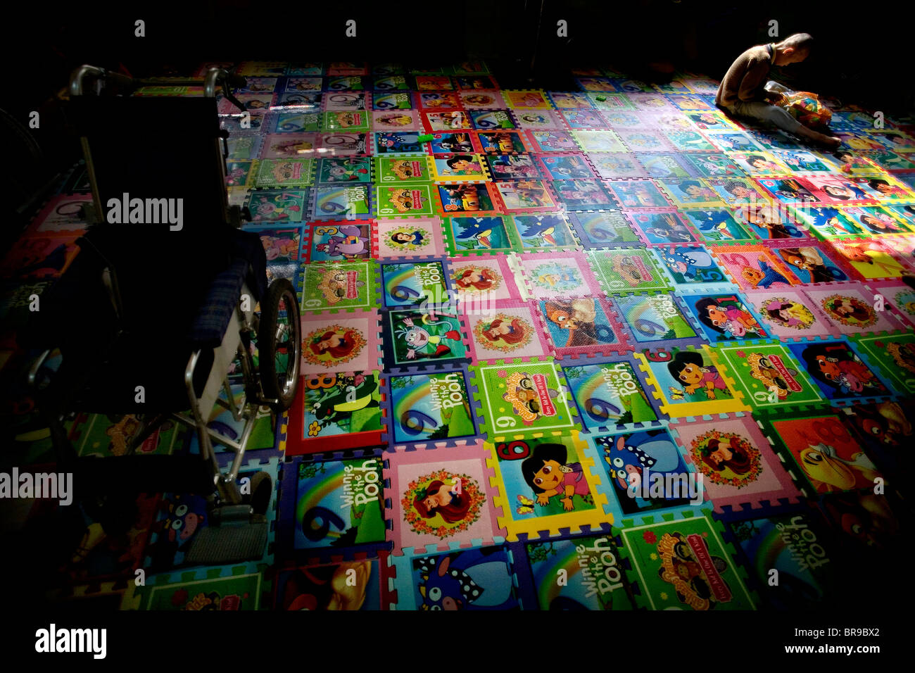Il ragazzo si siede lungo la riproduzione con i giocattoli di Hanoi, Vietnam. Foto Stock