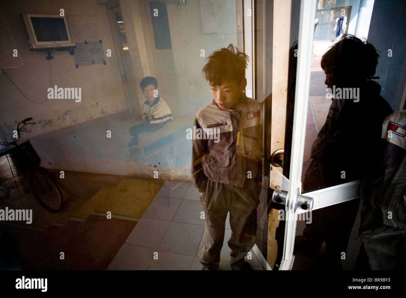 Ragazzo sorge accanto alla porta di Hanoi, Vietnam. (Riflessione) Foto Stock