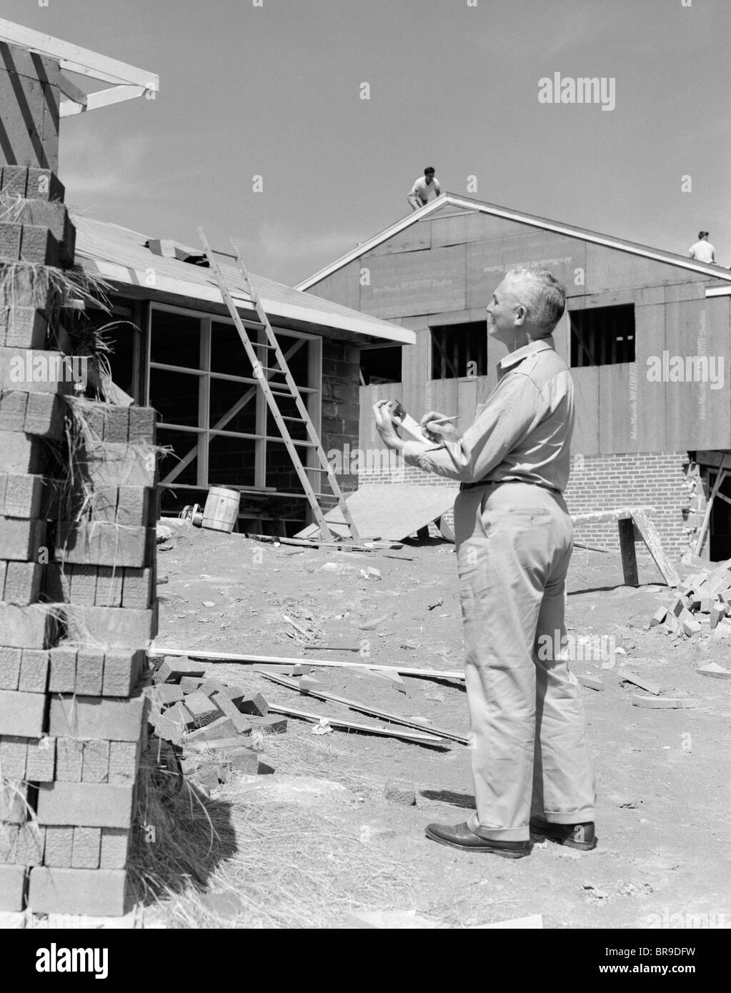 Anni Cinquanta SENIOR UOMO CON APPUNTI SUL SITO IN COSTRUZIONE Foto Stock