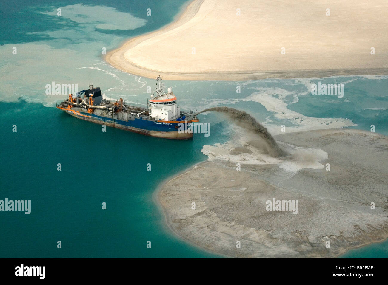 Un rimorchiatore pompaggio per la bonifica dei terreni nel Golfo off Dubai Foto Stock