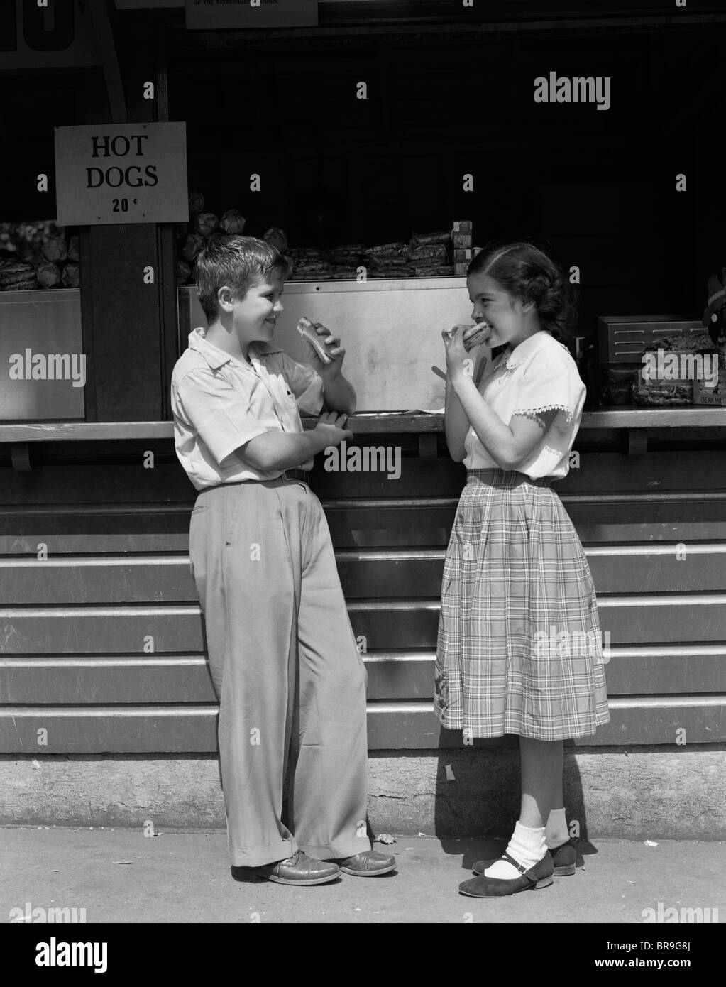 Anni Cinquanta ragazza ragazzo mangiare hot dogs A ESTRARRE STAND Foto Stock