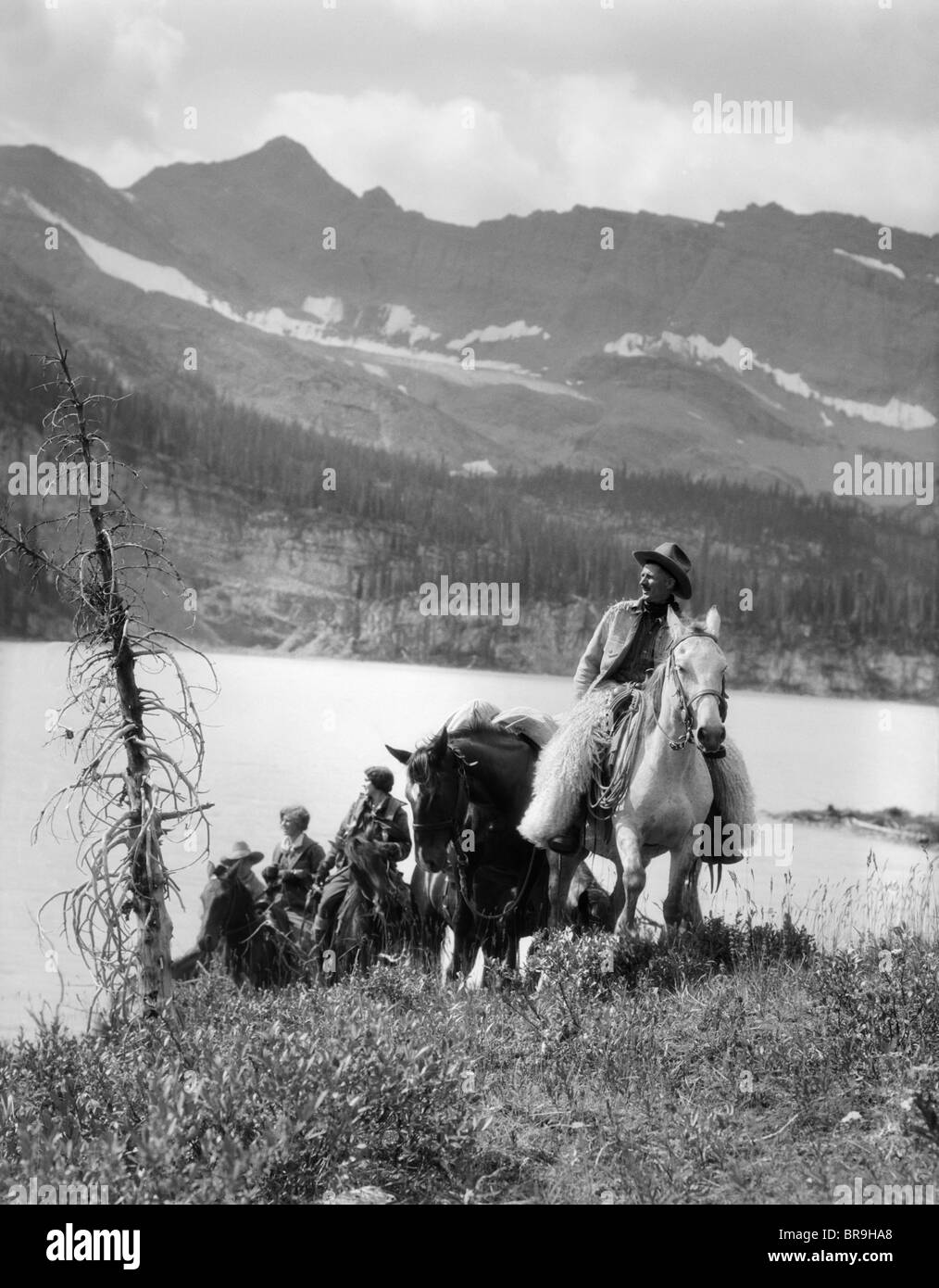 Anni Venti anni trenta due donne un uomo a cavallo western selle cowboy di lana che indossa CHAPS DAL LAGO DI MONTAGNA IN CANADA Foto Stock