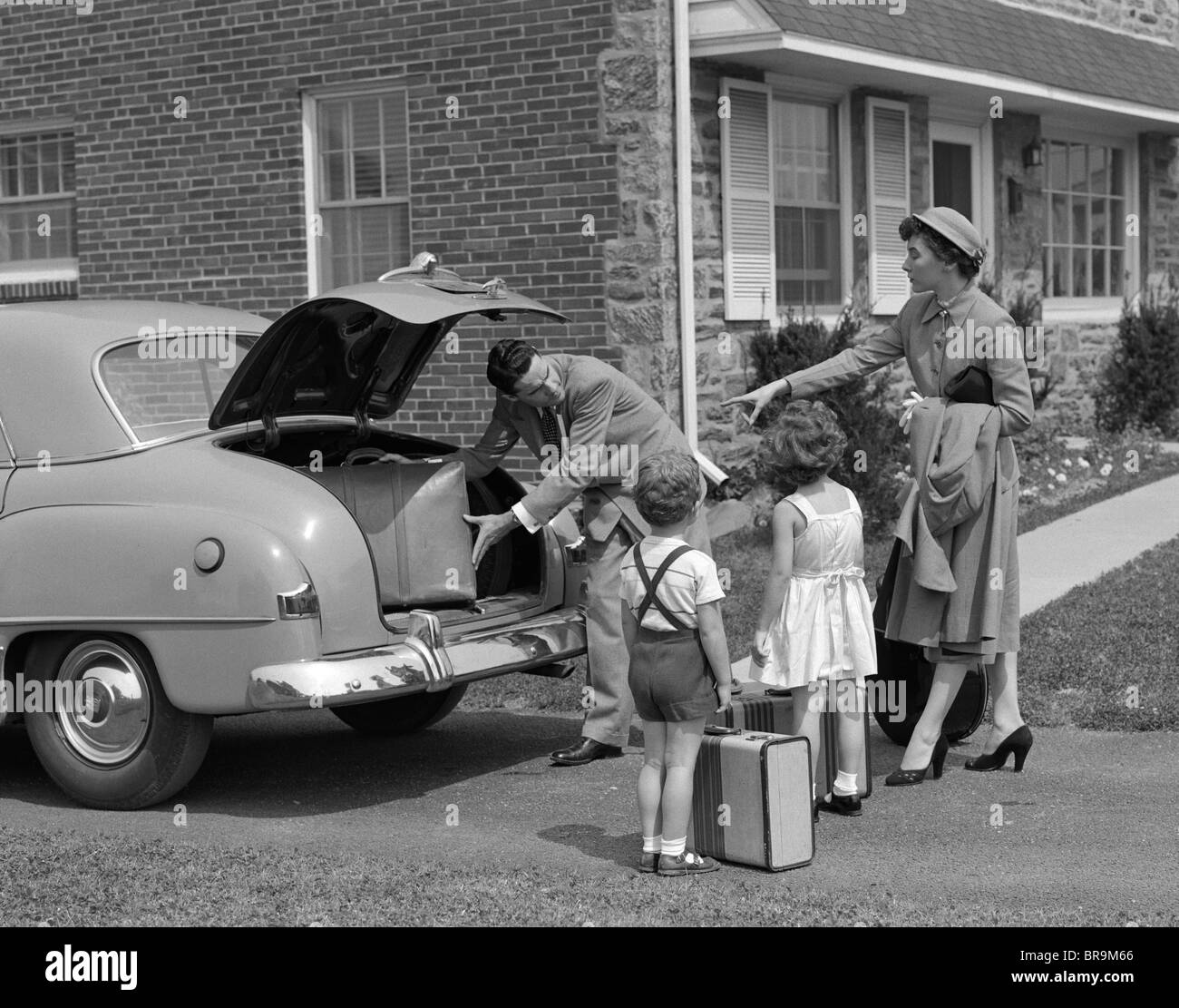 Degli anni Cinquanta la famiglia mettendo Bagagli Valigie in tronco di auto Foto Stock