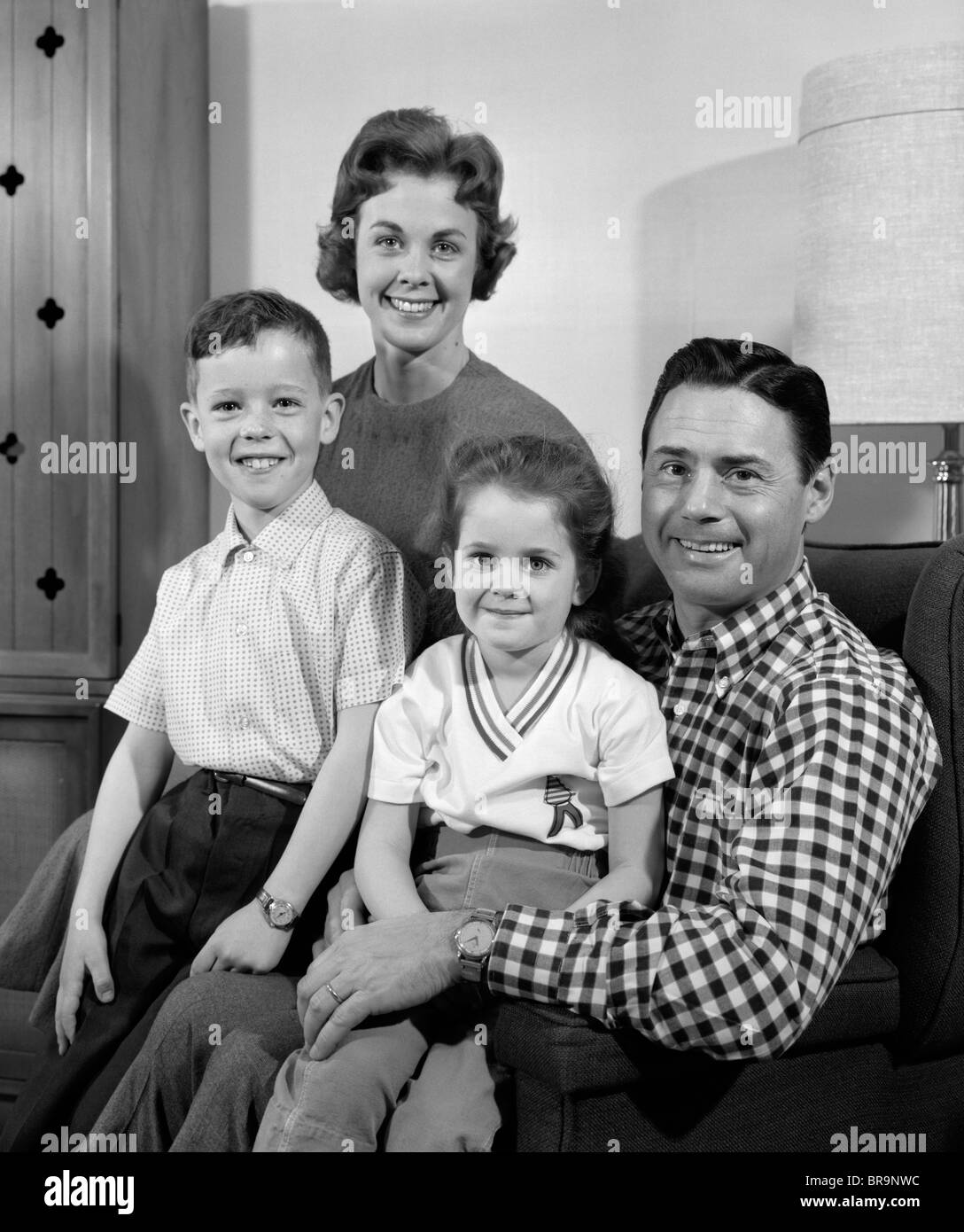 Negli anni sessanta la famiglia seduti sul divano a sorridere guardando la fotocamera Foto Stock