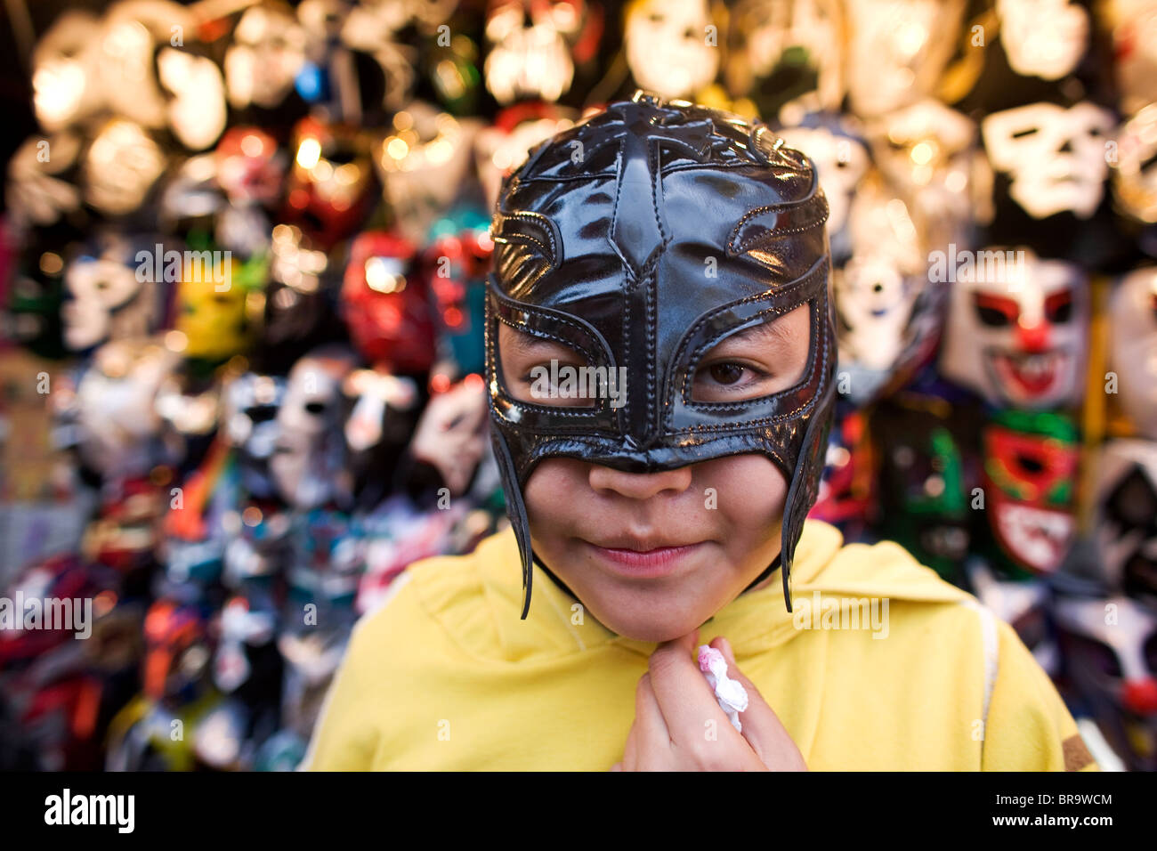 Un ragazzo cercando di maschera ad una Lucha Libre negozio di abbigliamento al di fuori di Puebla Arena Messico Foto Stock