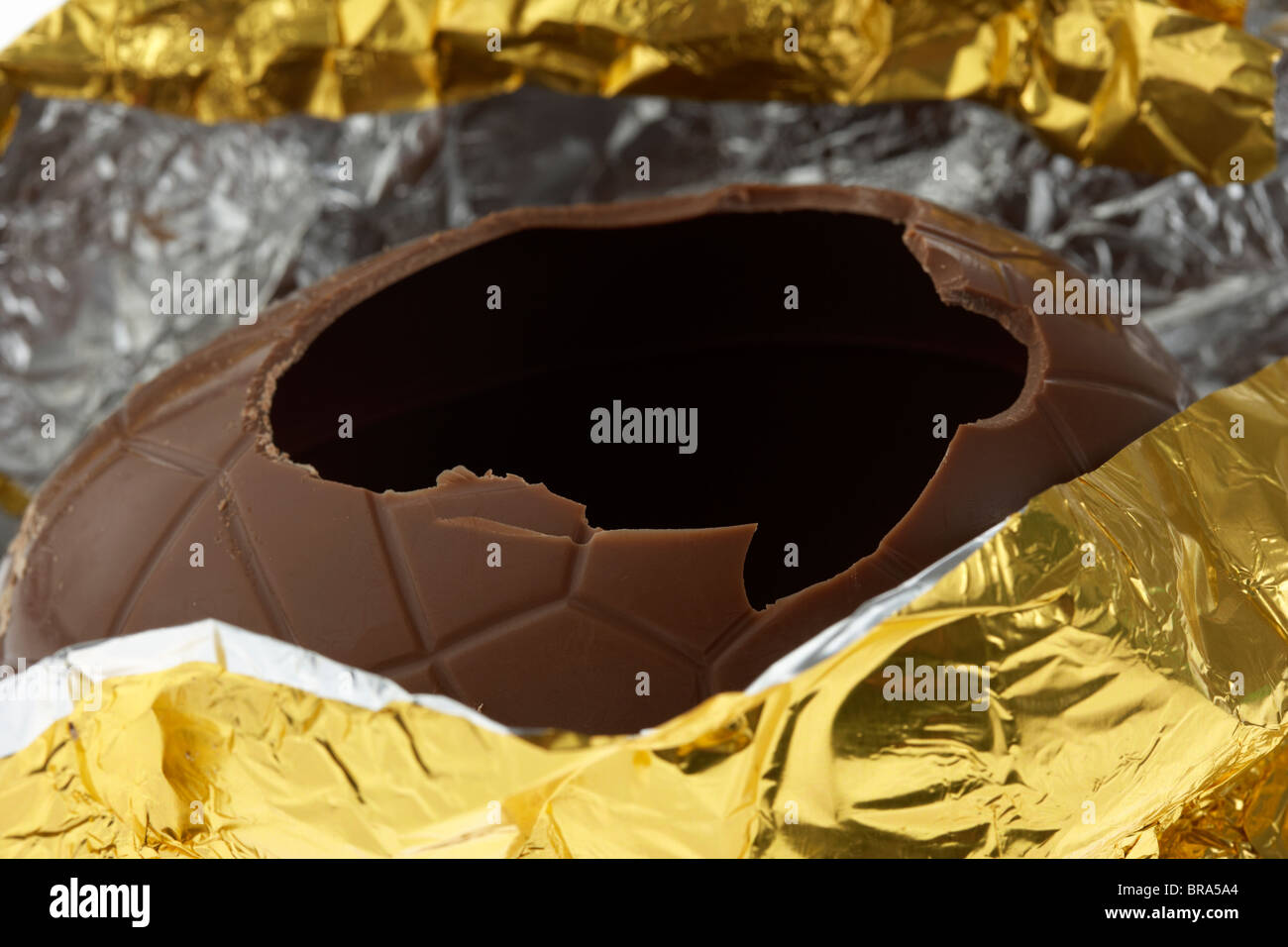 Oro stagnola avvolto uovo di pasqua aperto e incrinato Foto Stock