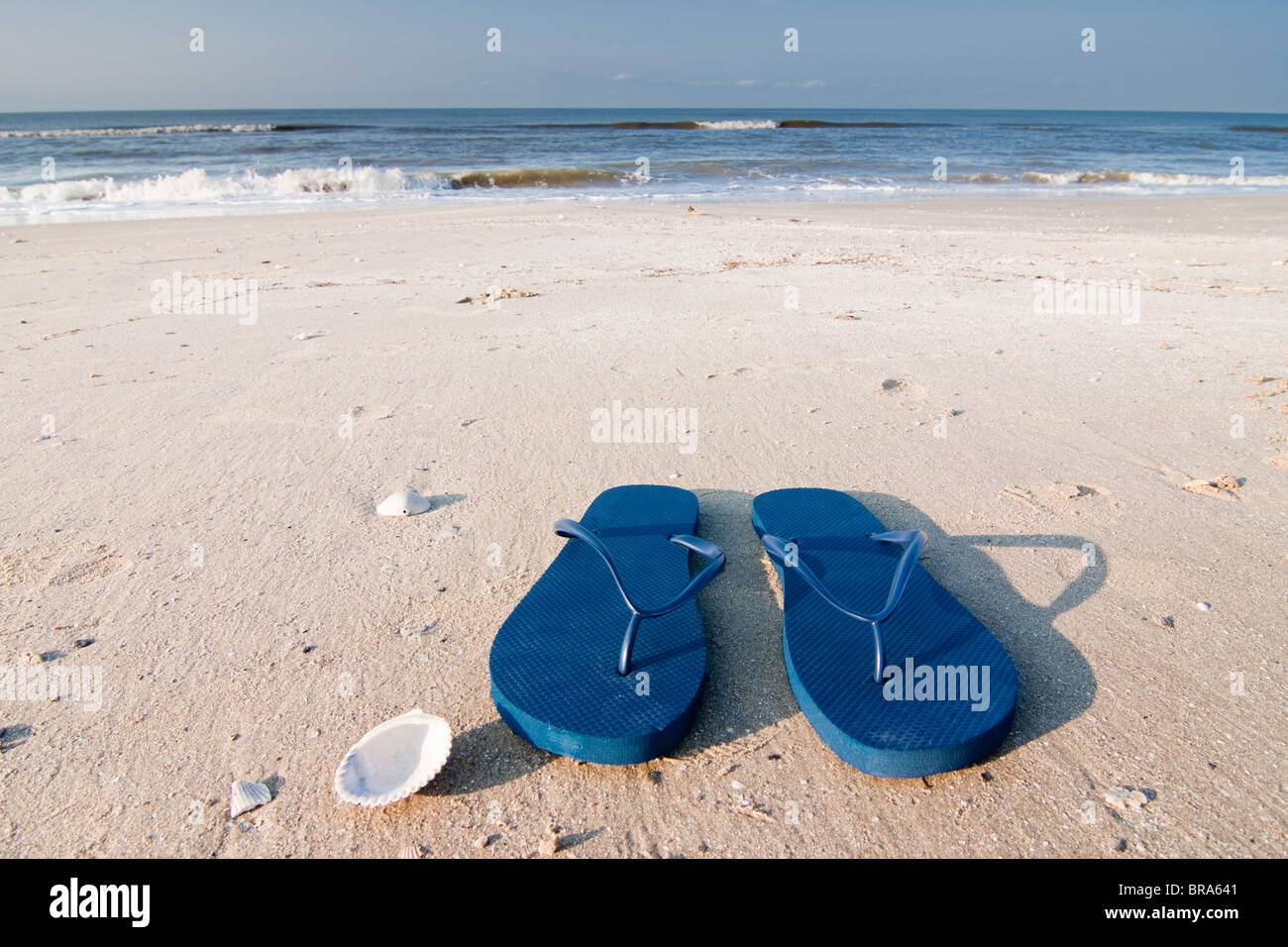 Coppia di sandali blu sulla sabbia a Holly spiaggia vicino Cameron, Louisiana sul Golfo del Messico. Foto Stock