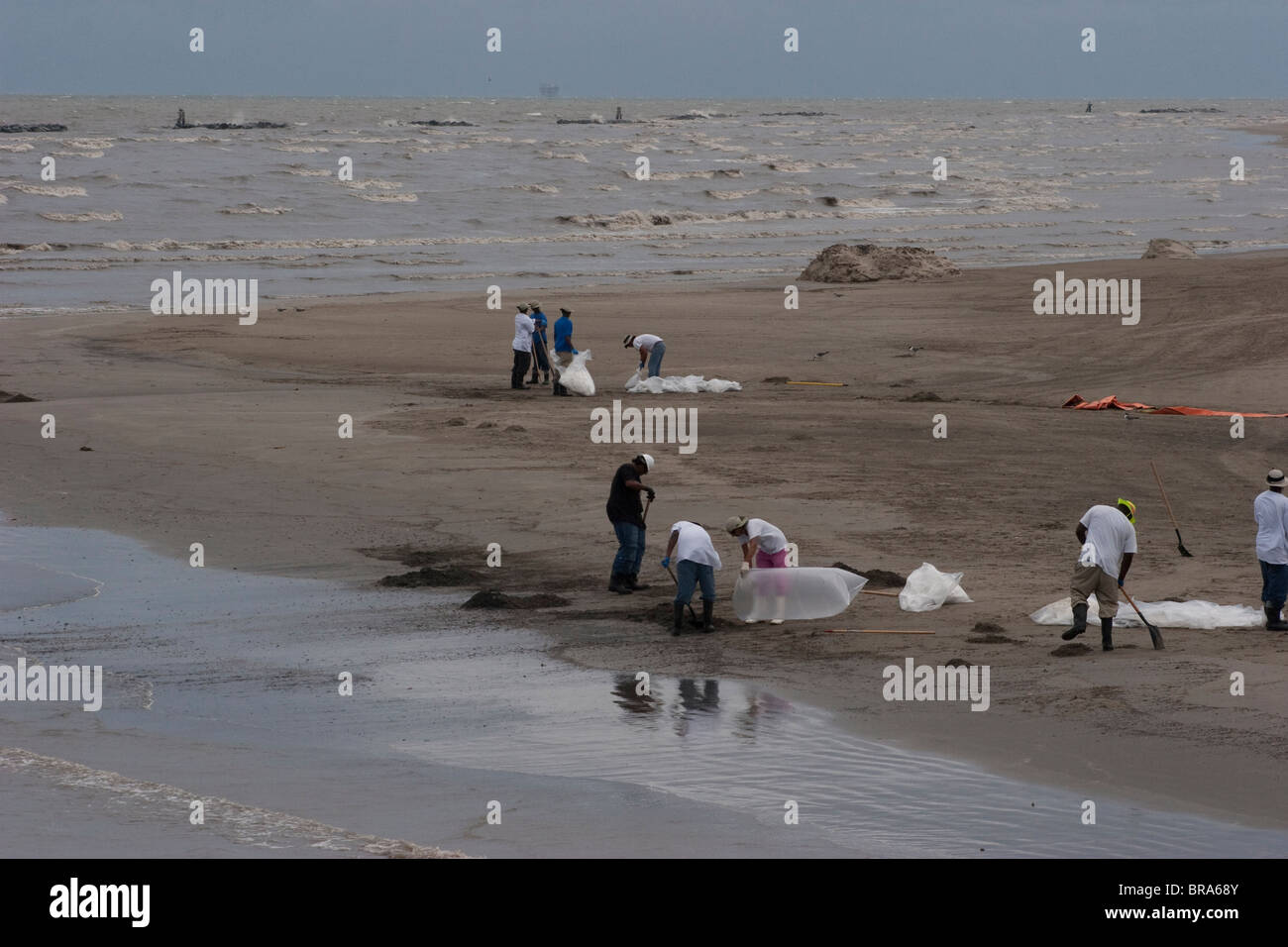 Il clean-up i lavoratori sulla spiaggia di Grand Isle, Louisiana rimuovere spiaggiata olio dalla BP fuoriuscita di petrolio nel golfo del Messico. Foto Stock