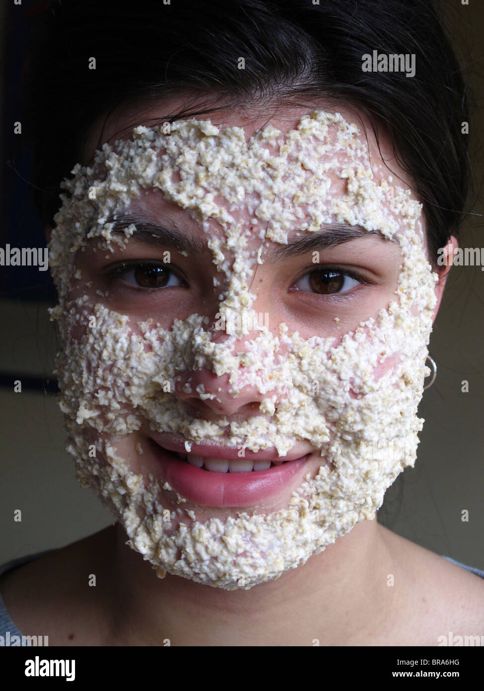 Ragazza adolescente utilizzando una maschera di avena per ripulire la sua pelle Foto Stock