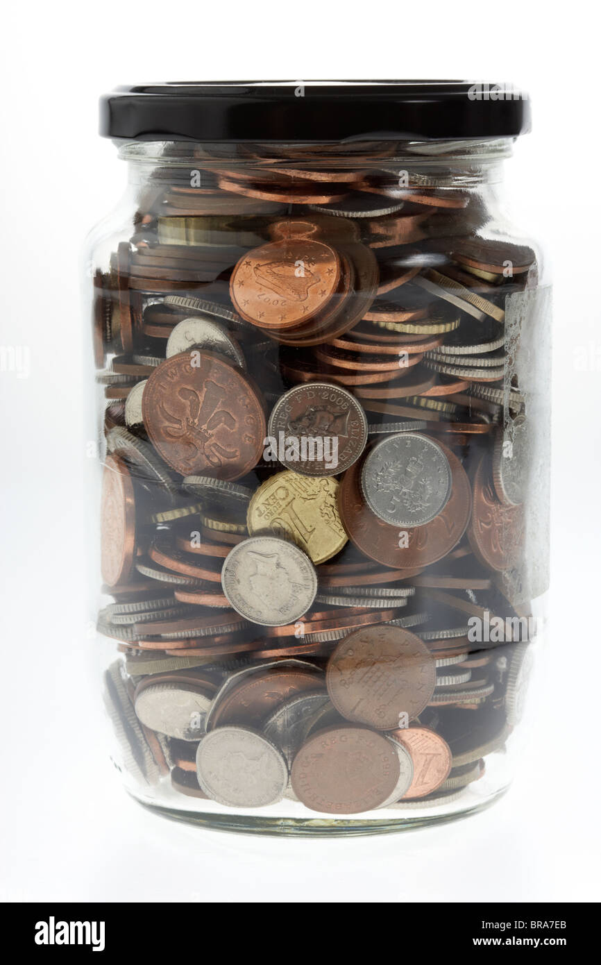 Vaso pieno di miste di sterling e monete in euro in un vecchio vasetto in vetro Foto Stock