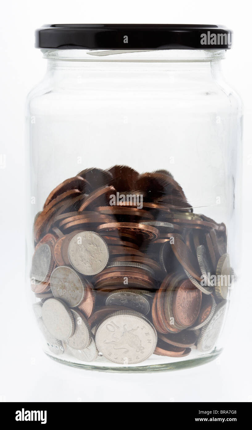 Il vaso pieno per metà di miscelati sterlina e delle monete in euro in un vecchio vasetto in vetro Foto Stock