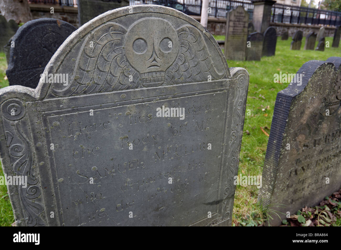 Una vecchia lastra tombale che mostra la testa di decessi Foto Stock