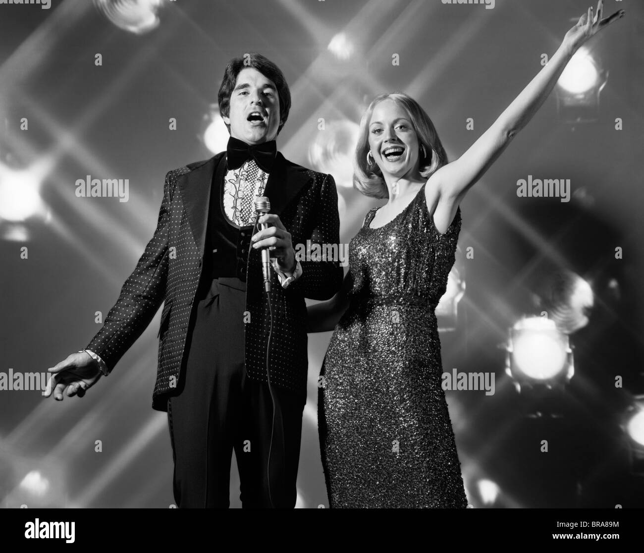 Anni Settanta l uomo e la donna cantare insieme eseguendo Foto Stock