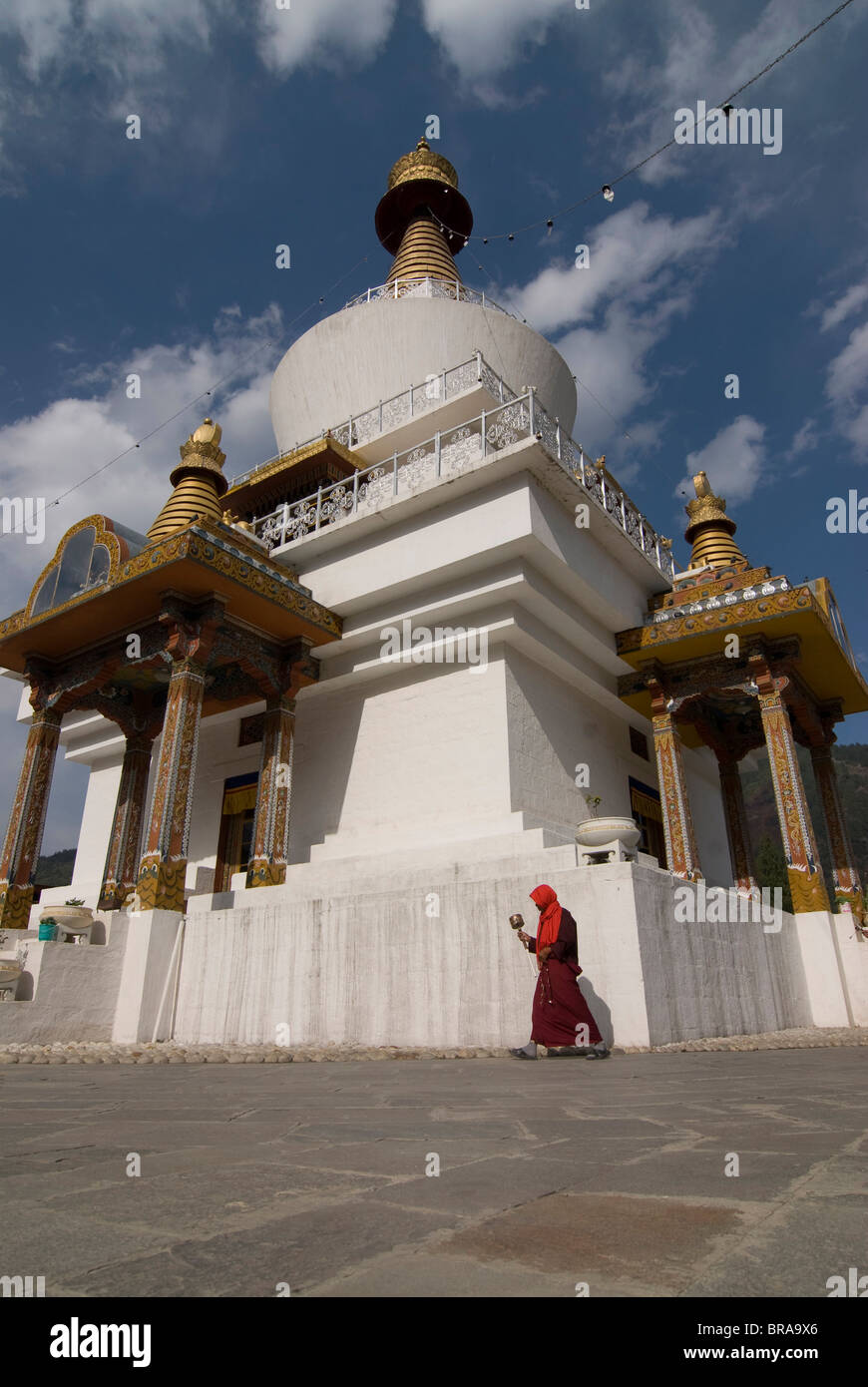 Pellegrino che circonda un stupa bianchi con ruota di preghiera in mano, Thimpu, Bhutan, Asia Foto Stock