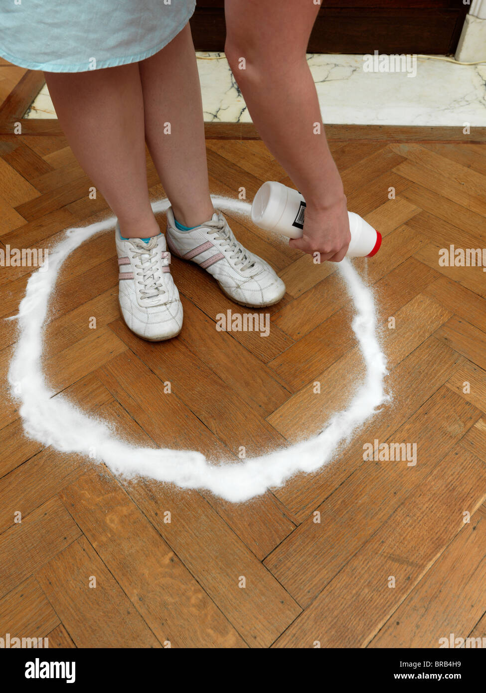 Una donna caucasica spruzzando un cerchio di sale intorno a se stessa Foto Stock