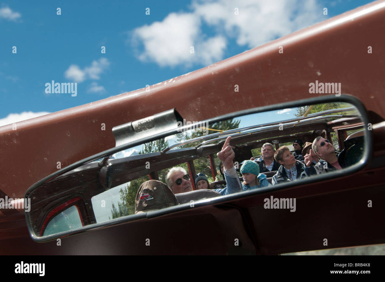 I passeggeri a bordo del bus rosso specchio, andando-per-il-Sun Road, il Parco Nazionale di Glacier, Montana. Foto Stock