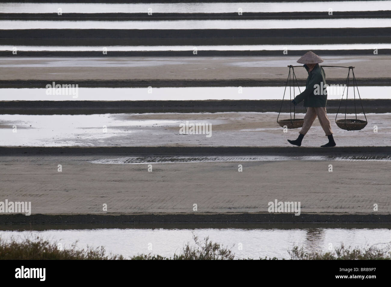Donna che trasportano sale sul funzionamento di sale, Vietnam, Indocina, Asia sud-orientale, Asia Foto Stock