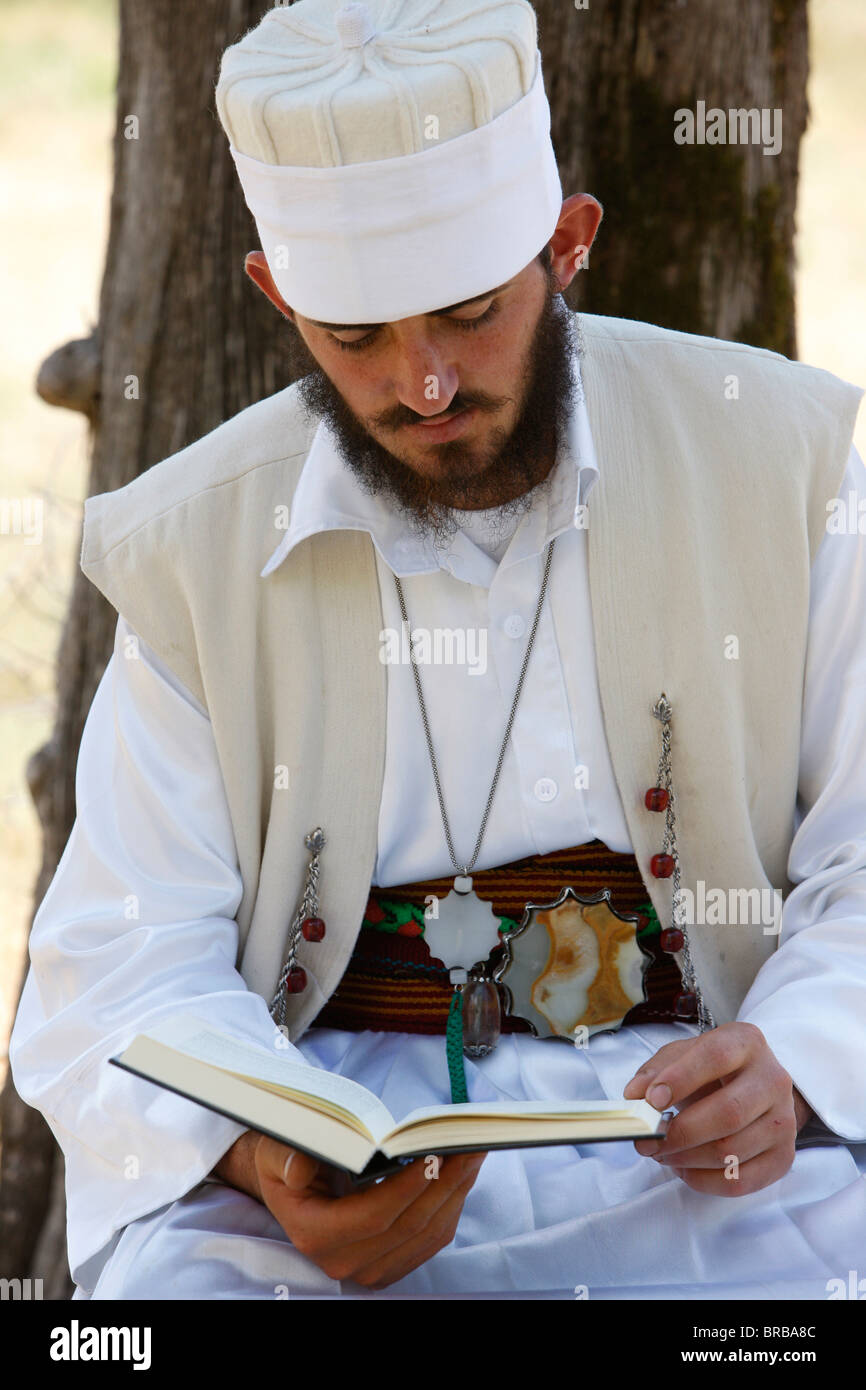 Un 22-anno vecchio dervish, Myrteza Shehu, lettura sotto un albero in Melani tekke, Vranishti, Girokastre, Albania Foto Stock