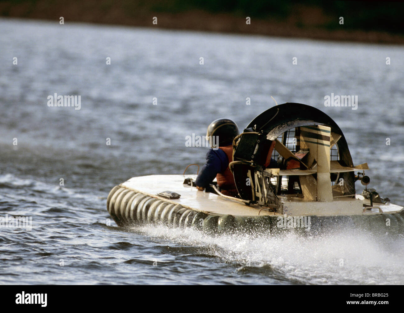 Pilota di hovercraft vola il suo mestiere lungo per via navigabile Foto Stock