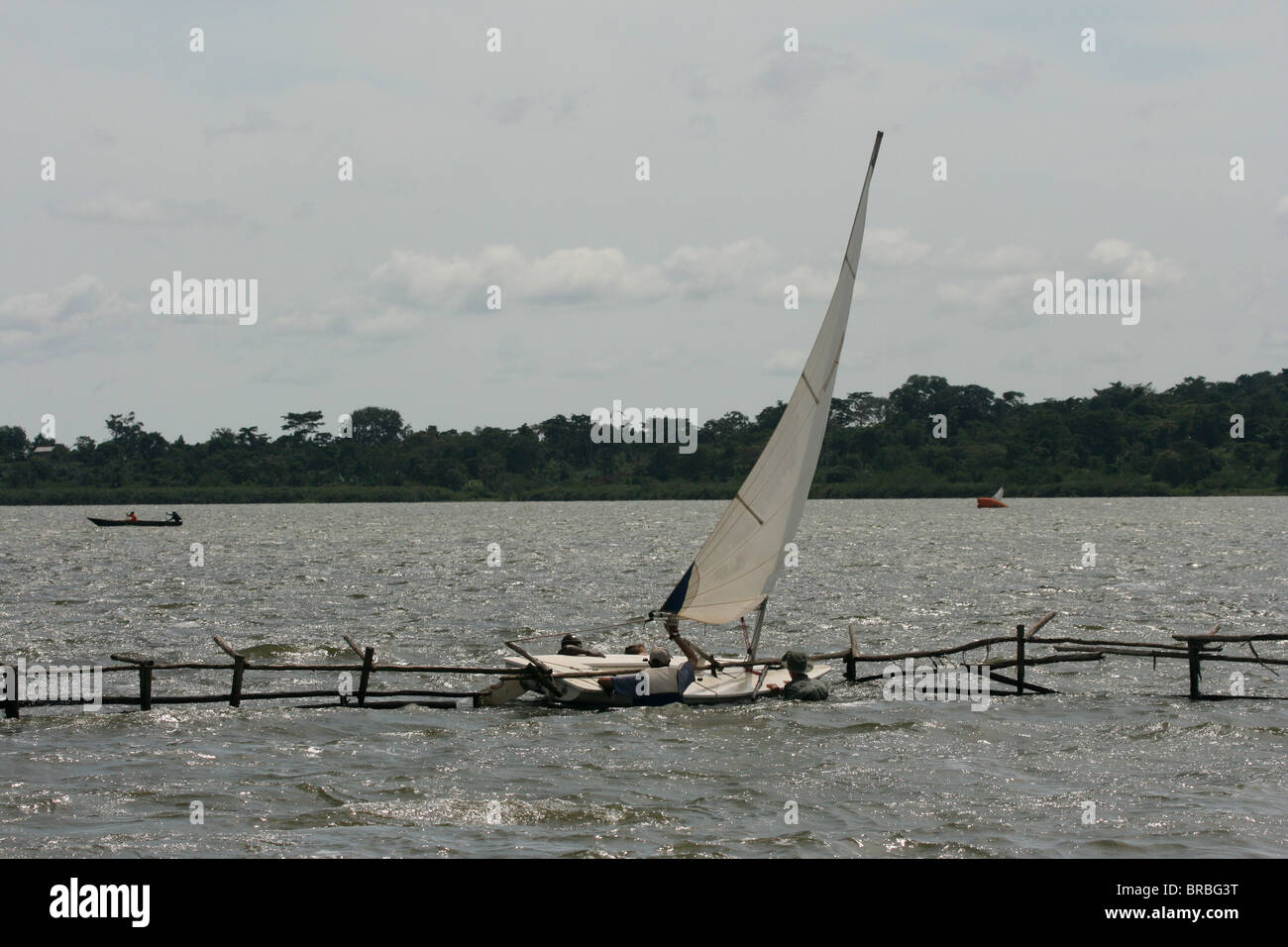 Un laser radiale dinghy essere liberato da una struttura in acqua che era stato bruciato in, il lago Victoria, Uganda Foto Stock