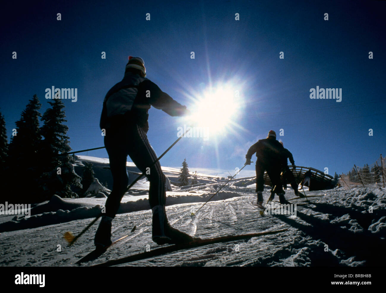 I fondisti andare in salita contro la scalata sun Foto Stock
