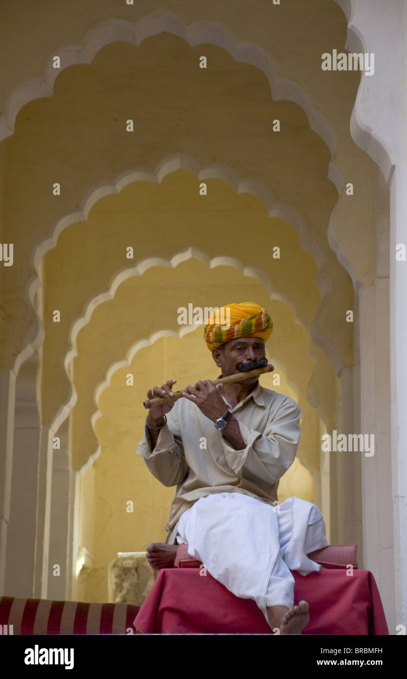 Un uomo nel tradizionale abito indiano riproduzione di un flauto di legno al Meherangarh Fort di Jodhpur, Rajasthan, India Foto Stock