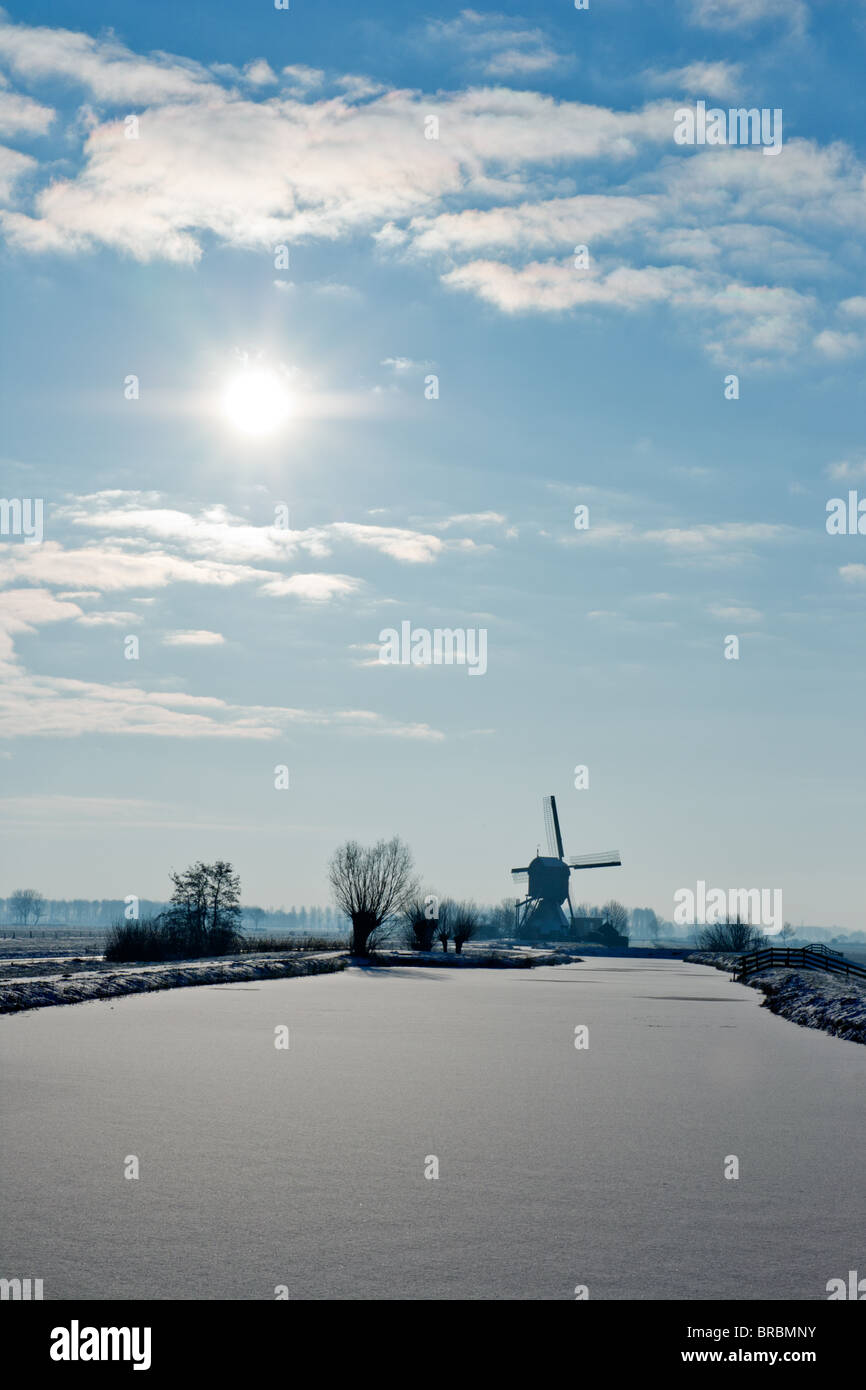 Frozen River e il mulino a vento olandese in un freddo winterday Foto Stock