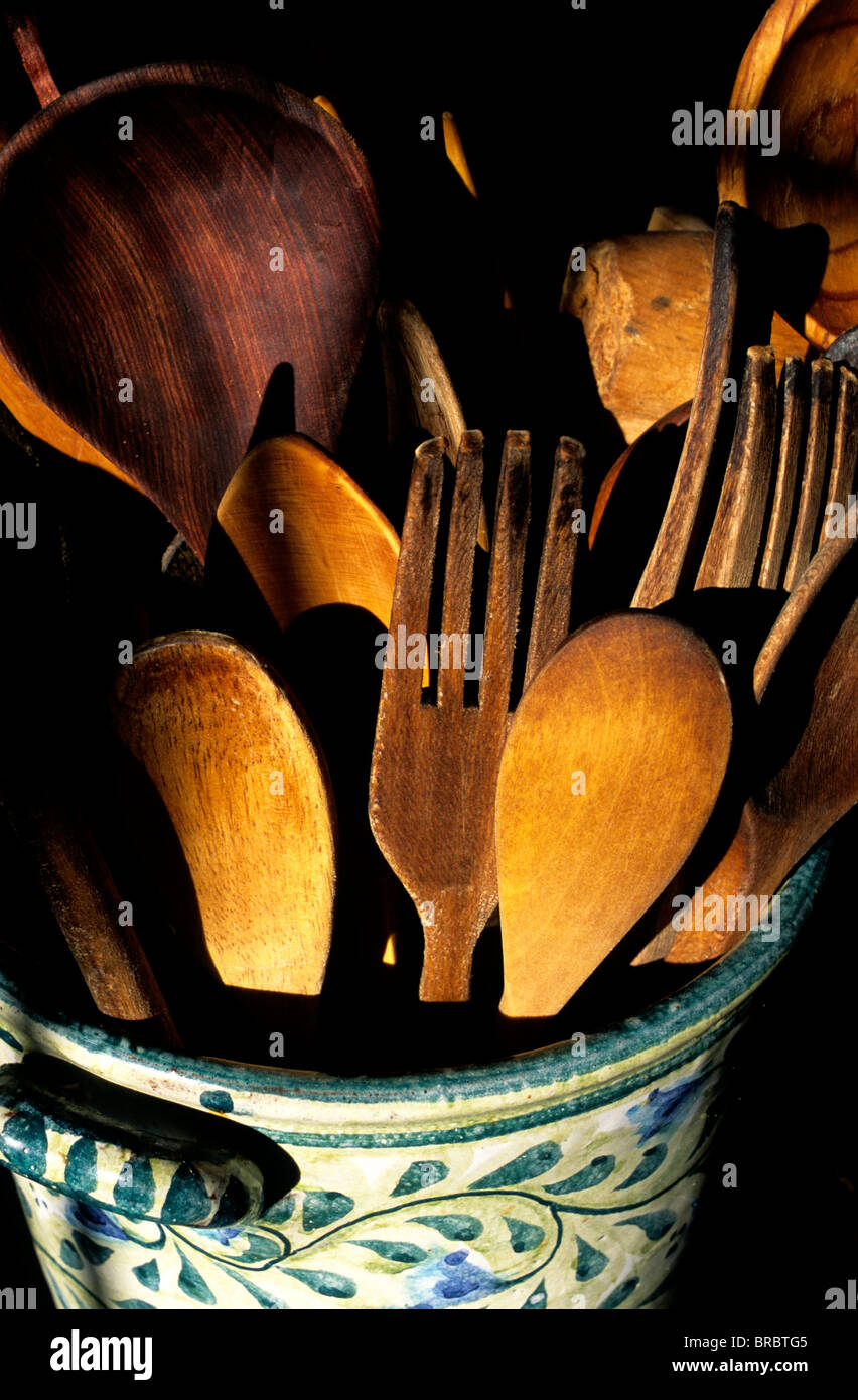 In legno utensili di cottura impilati in un decorato vaso in ceramica Foto Stock