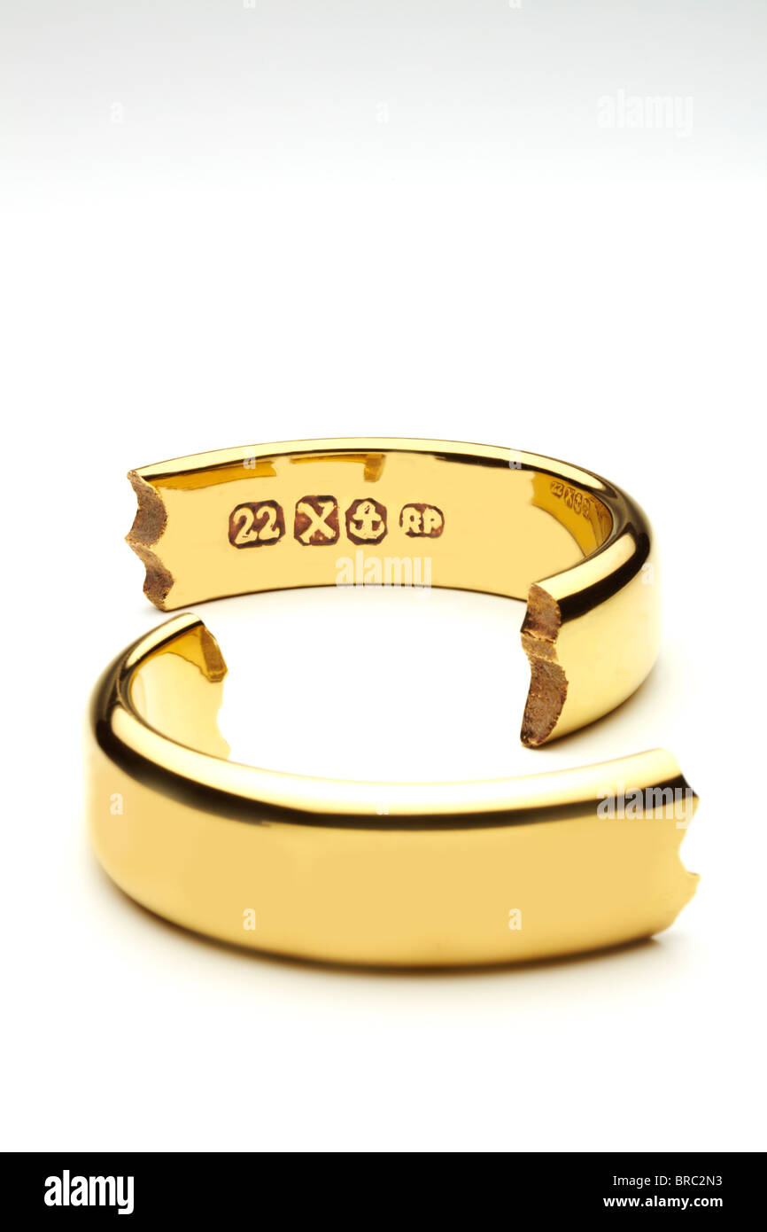Oro rotto l'anello nuziale che simboleggiano il matrimonio si rompono Foto Stock