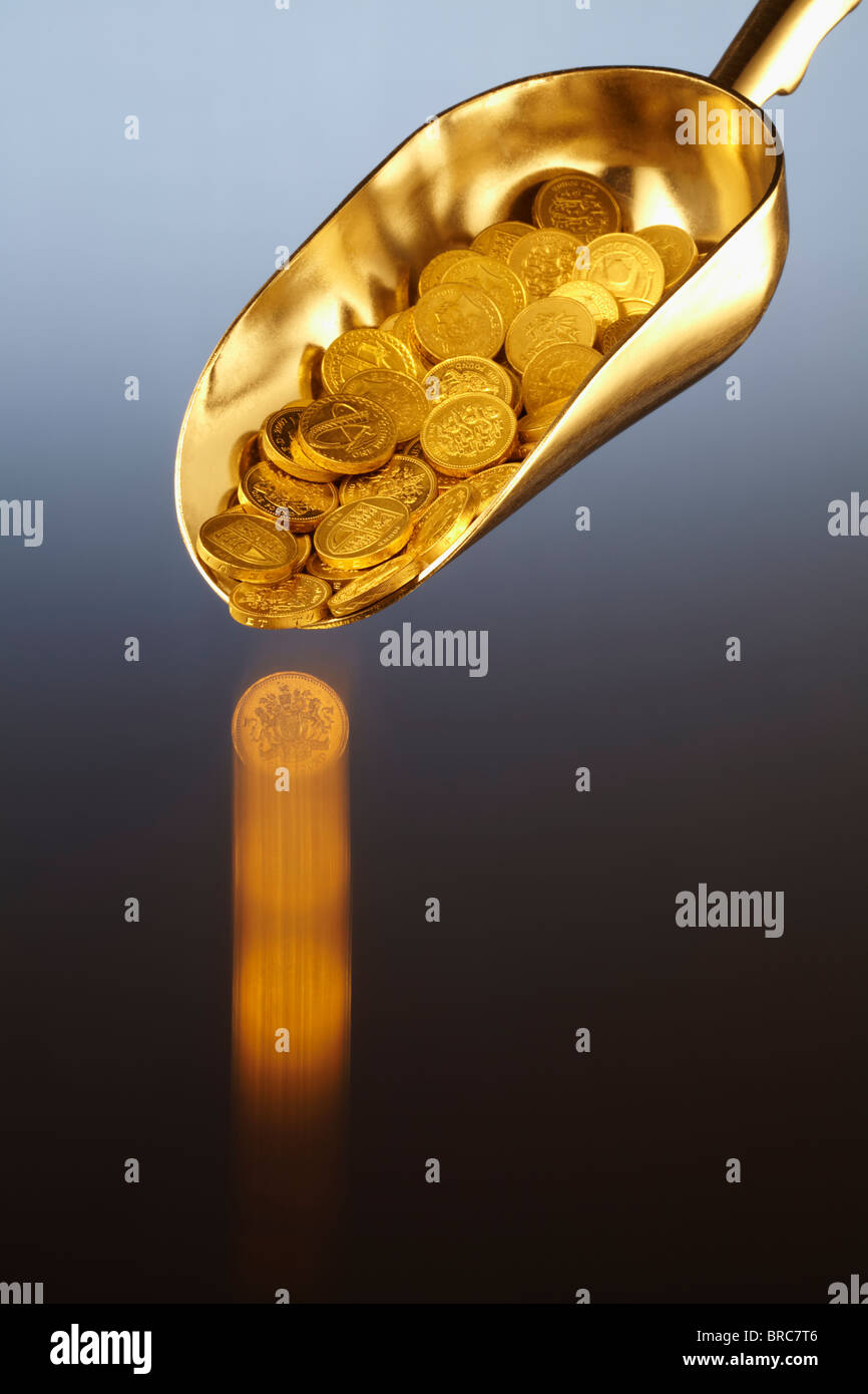Golden scoop di denaro con la caduta della sterlina moneta Foto Stock