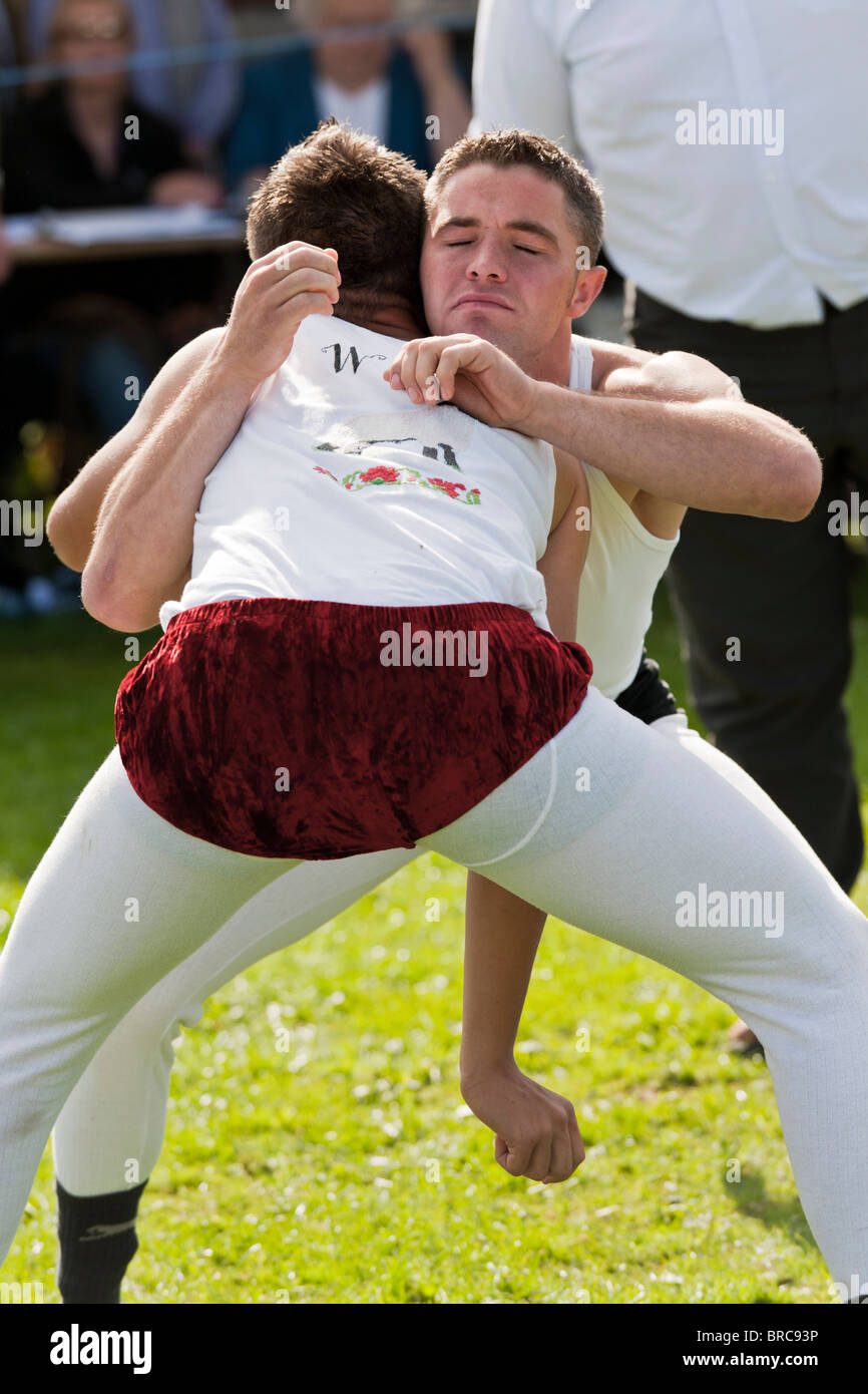 Lottatori di pennini indossando costumi tradizionali presso la Westmorland Visualizza Foto Stock