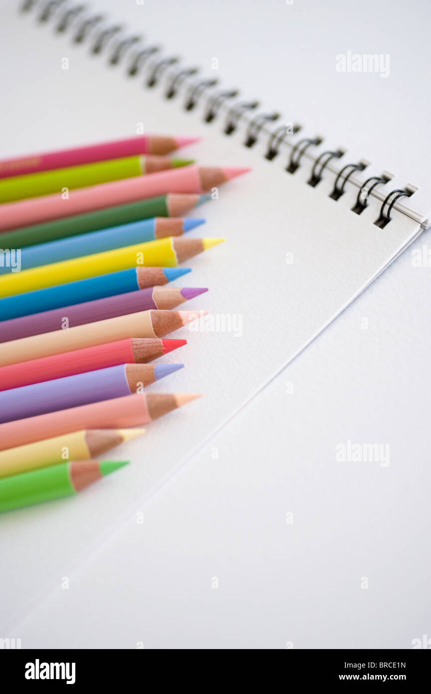 Matite colorate e notebook Foto Stock