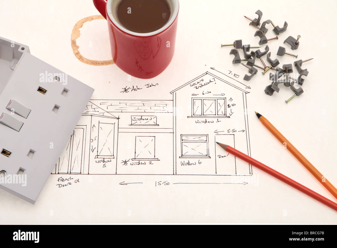 Un elettricisti grezzi schizzo blueprint, Regno Unito presa elettrica di uscita e una tazza di caffè. Foto Stock