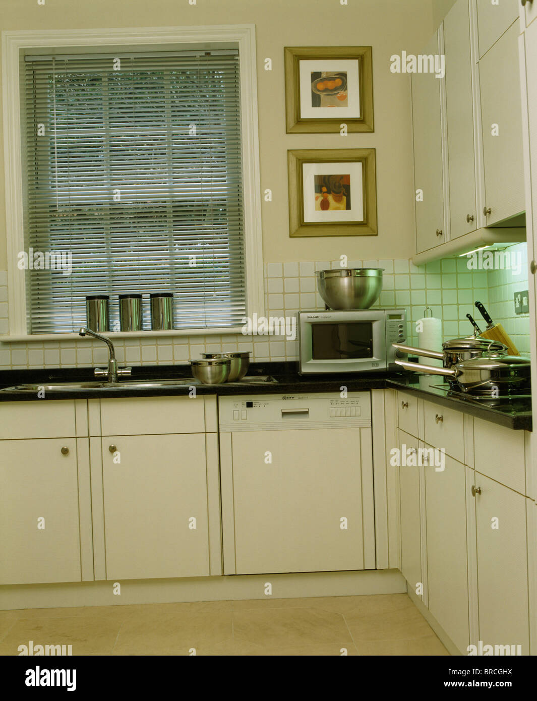 Tenda a veneziana sulla finestra sopra il lavabo e dotato di lavastoviglie  in una moderna casa cittadina bianca cucina Foto stock - Alamy