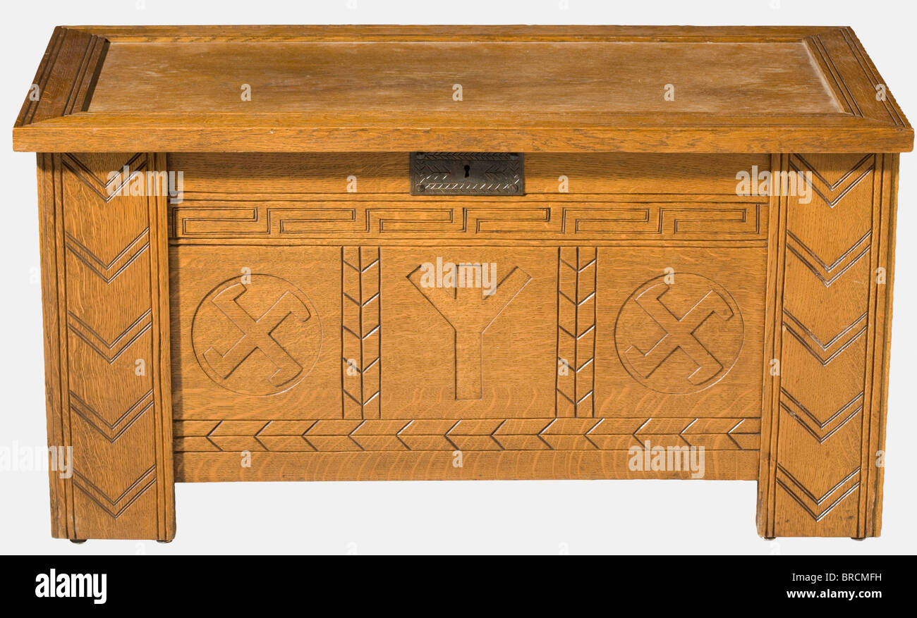 Un SS-Sippentruhe (petto di famiglia), per la nascita di un bambino un petto di quercia in stile nordico con bande scolpite di meandro sul lato anteriore e tre simboli: Al centro la runa di vita (nascita del bambino) fiancheggiata da ruote sole aperte come emblemi di salvezza. La f storica, storica, 1930s, 20th secolo, Waffen-SS, divisione armata delle SS, servizio armato, servizi armati, NS, nazional socialismo, nazismo, Terzo Reich, Reich tedesco, Germania, militare, militare, utensile, attrezzatura, utensili, oggetto, oggetti, alambicchi, clippings, cut-out, cut-out, cut-out, cut, Foto Stock