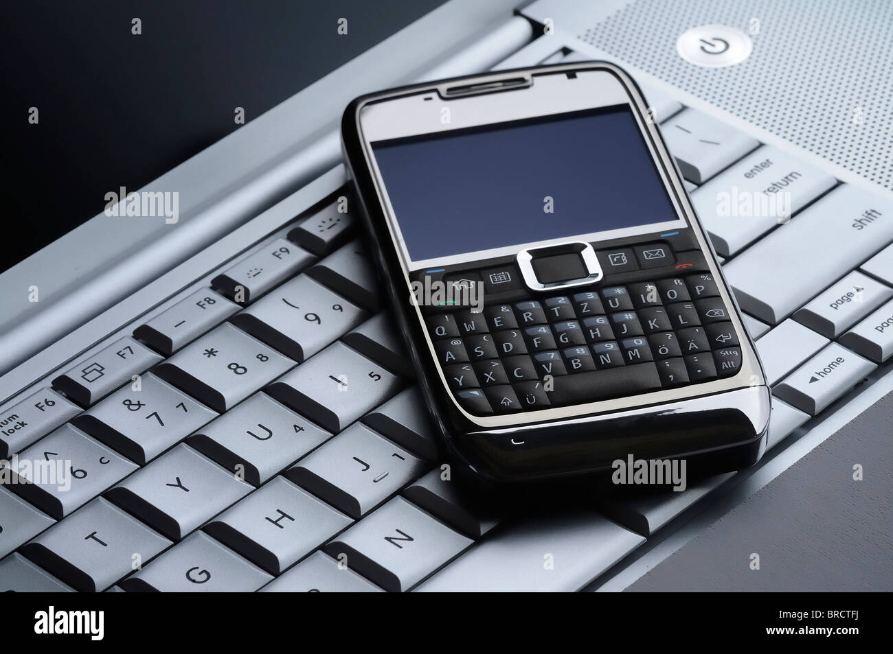 Close-up di una smart telefono cellulare su un laptop di argento Foto Stock