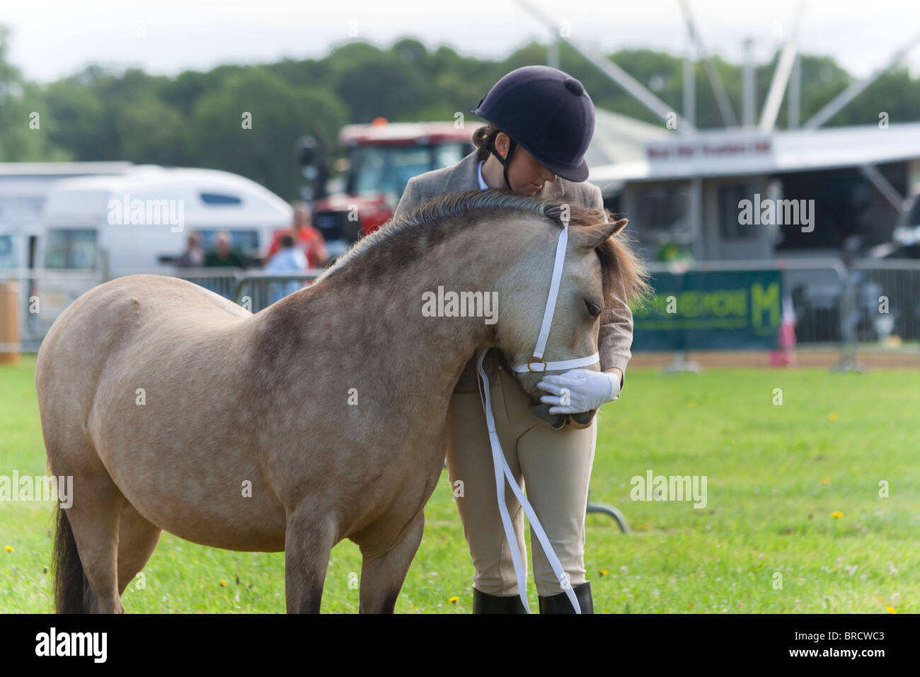 Piuttosto giovane donna che abbraccia il suo pony come hanno giocato in uno spettacolo di cavalli in Inghilterra rurale Foto Stock